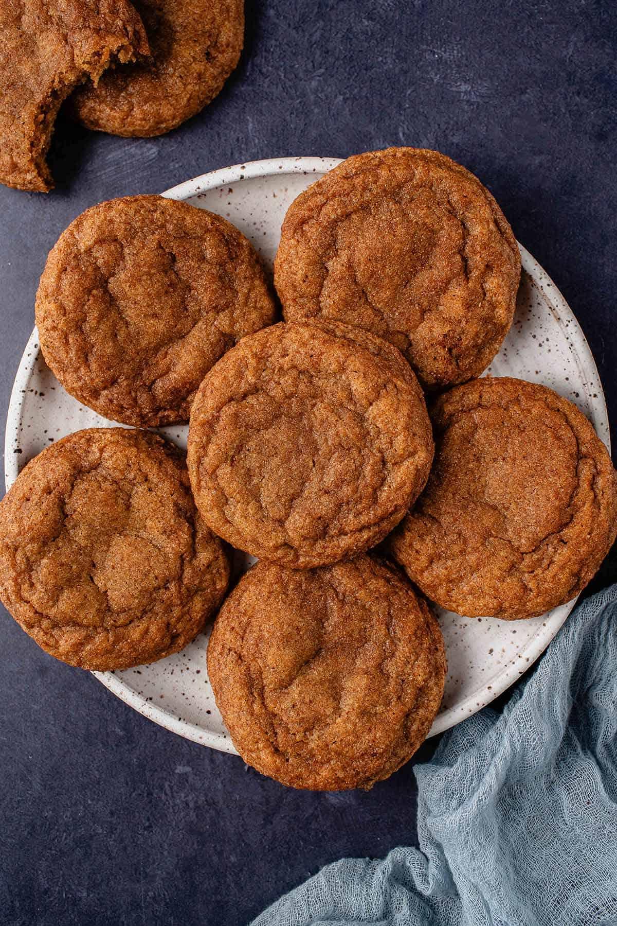 6 vegan pumpkin sugar cookies on white plate