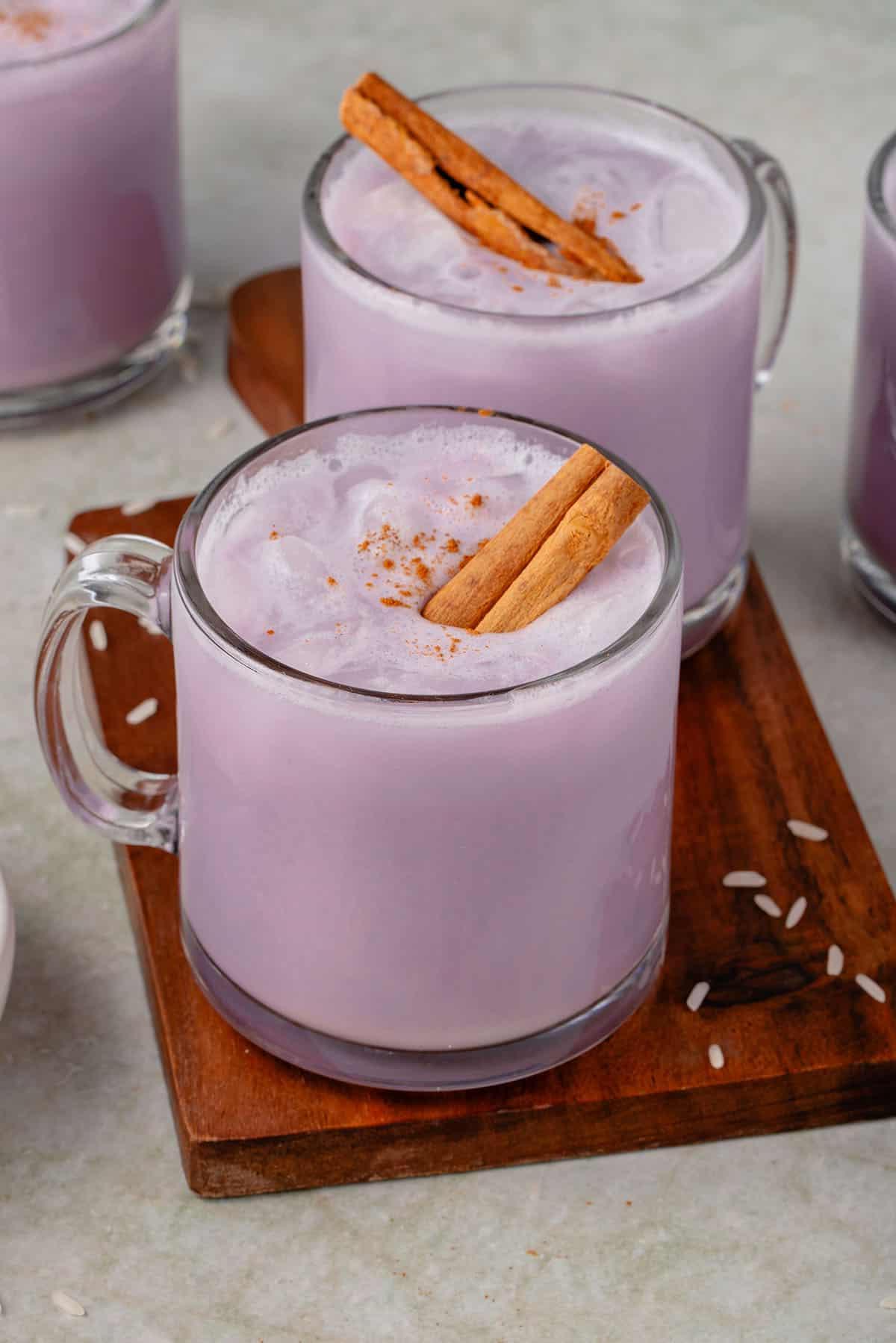 Ούμπε Ορτσάτα (Βίγκαν) 2 close up photo of 4 glasses of ube horchata styled on wooden cutting board