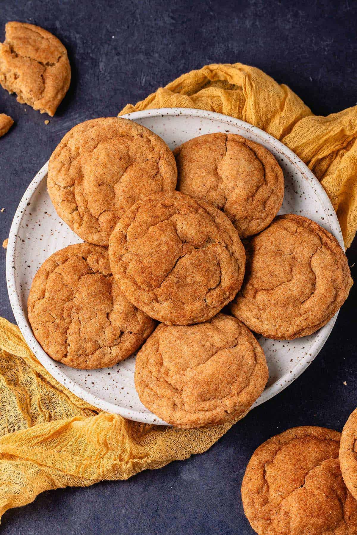 Σνικερντούντλς Κολοκύθας 2 Μπισκότα snickerdoodles κολοκύθας σε πιάτο με κίτρινη πετσέτα