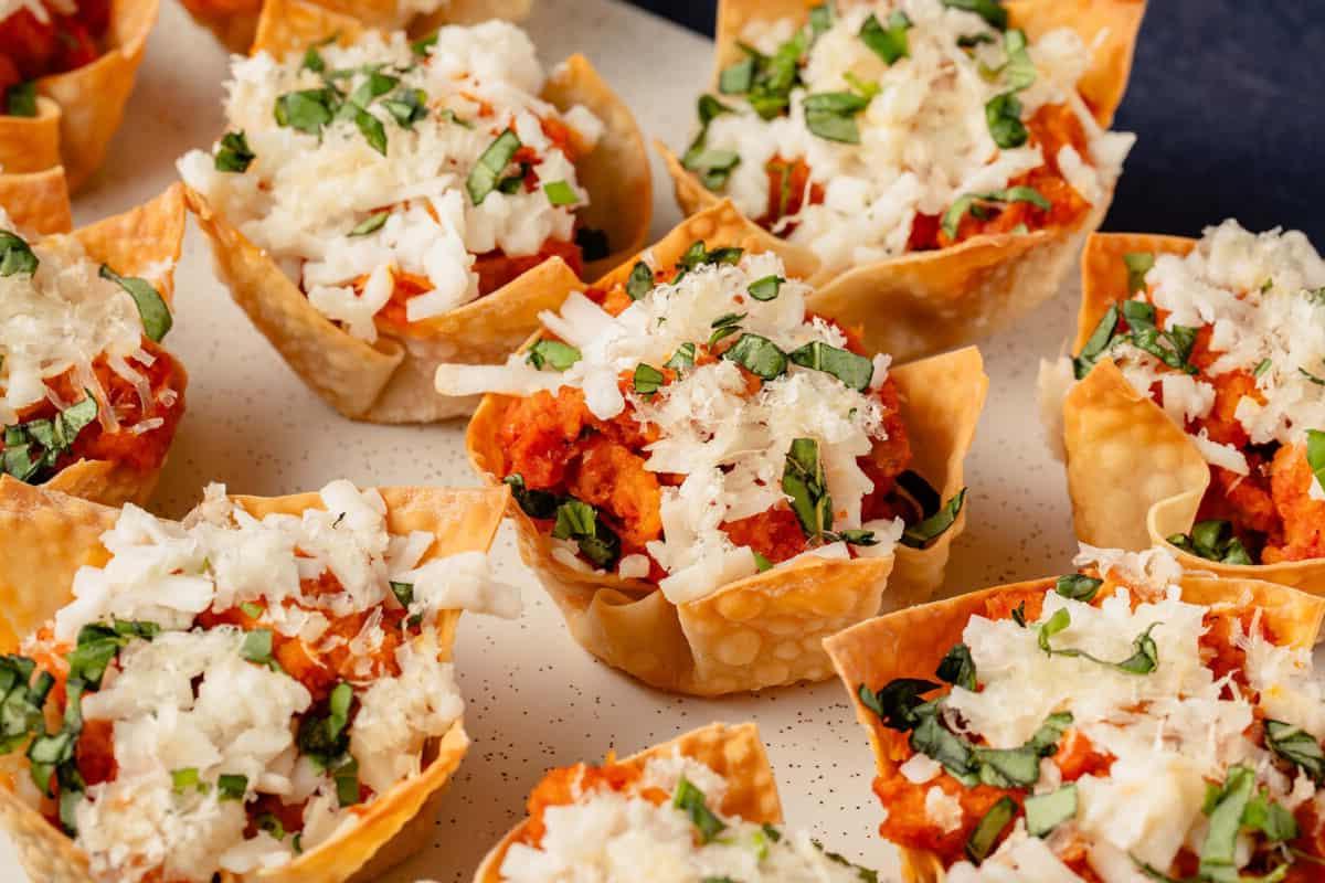 Βίγκαν κύπελλα wonton κοτόπουλο παρμεζάνα σε μακρύ λευκό πιάτο