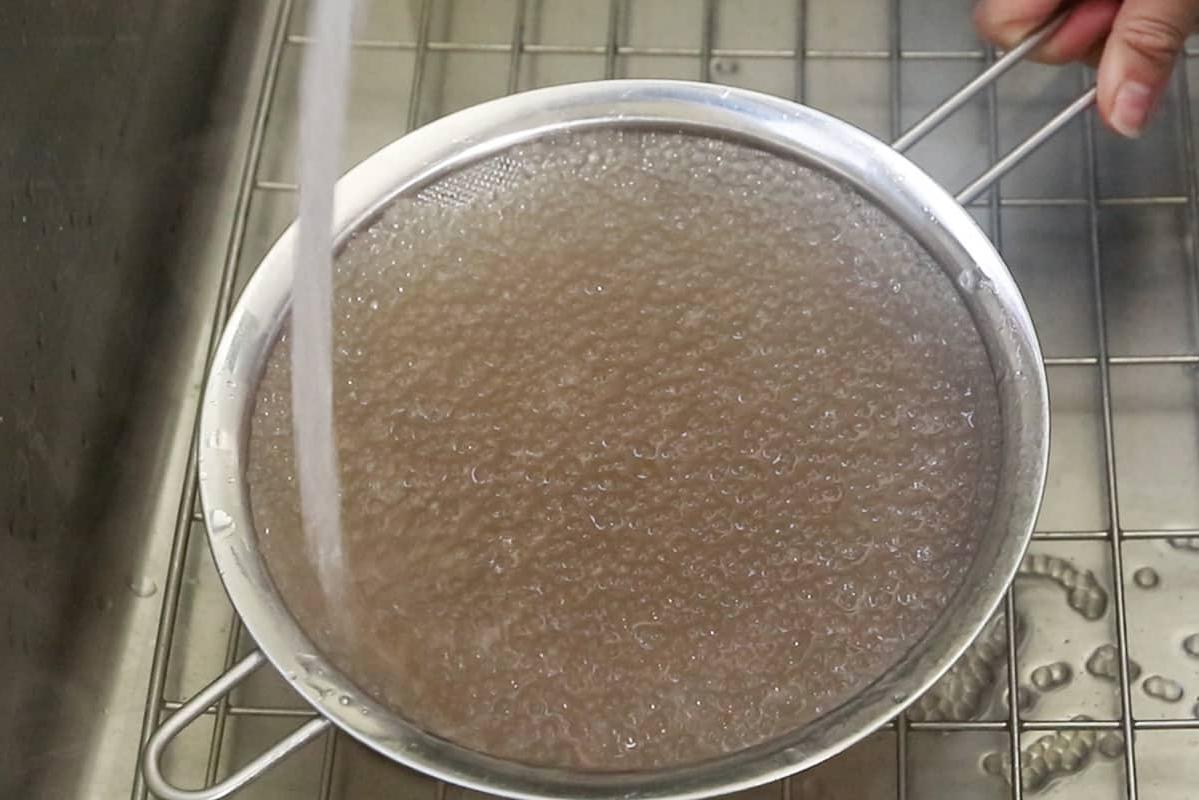 Ξέπλυμα μαγειρεμένων μαργαριταριών ταπιόκας σε σήτα