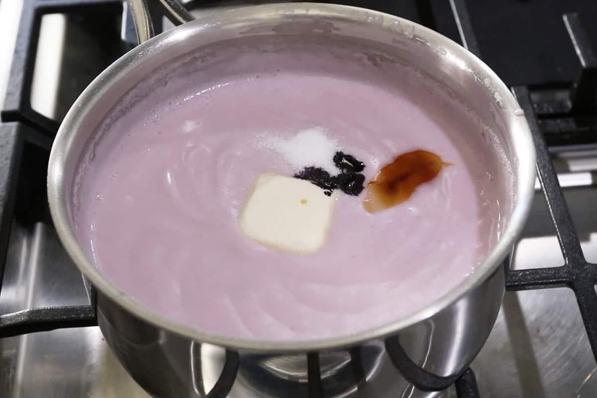 adding dairy free butter, vanilla, and ube extract to batter in a pot
