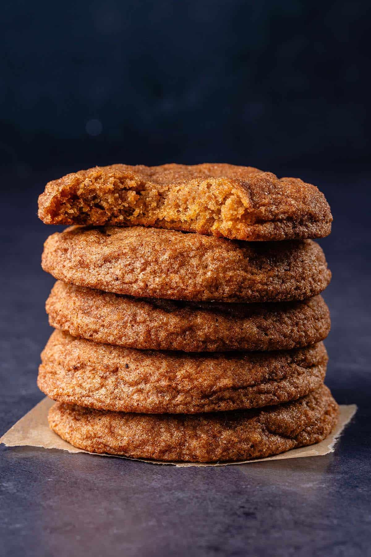 stack of vegan pumpkin sugar cookies on parchment paper