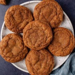 6 vegan pumpkin sugar cookies on white plate