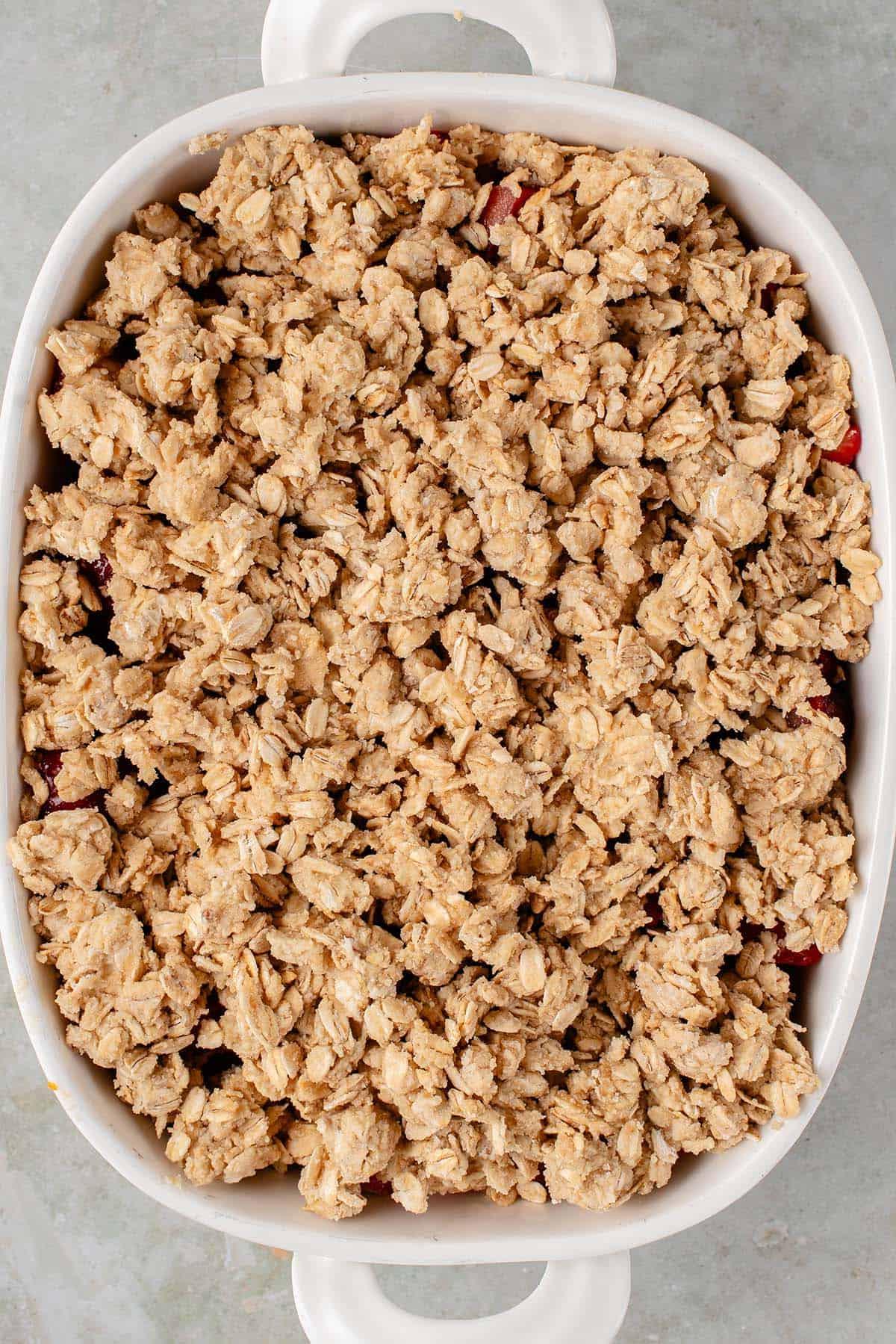 Βέγκαν Κραμπλ Φράουλας και Ραβεντιού 15 overhead photo of vegan strawberry rhubarb crisp in white baking dish before baking