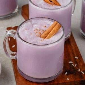 Ούμπε Ορτσάτα (Βίγκαν) 17 close up photo of 4 glasses of ube horchata styled on wooden cutting board