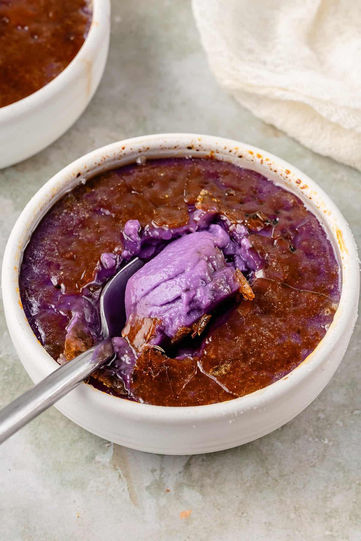 scooping the Ube Creme Brûlée out of a white container
