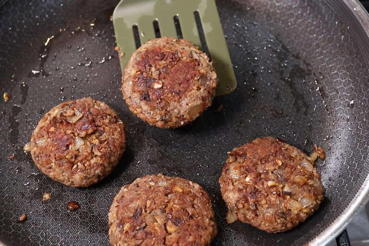 Ψημένα μπιφτέκια μπριζόλας burger σε τηγάνι