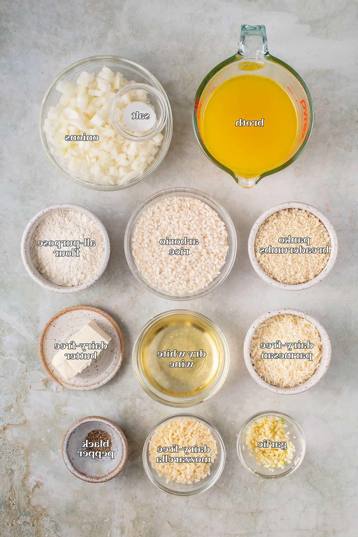 ζωμός, αλάτι, κρεμμύδια, φρυγανιά panko, ρύζι arborio, αλεύρι για όλες τις χρήσεις, vegan παρμεζάνα, ξηρό λευκό κρασί, vegan βούτυρο, σκόρδο, vegan μοτσαρέλα, μαύρο πιπέρι