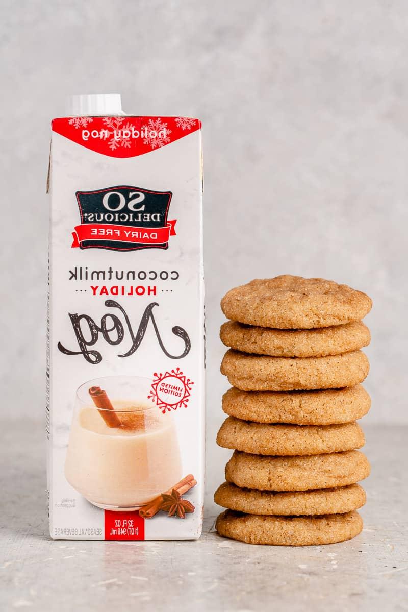Μια στοίβα από snickerdoodles δίπλα σε ένα κουτί βίγκαν eggnog
