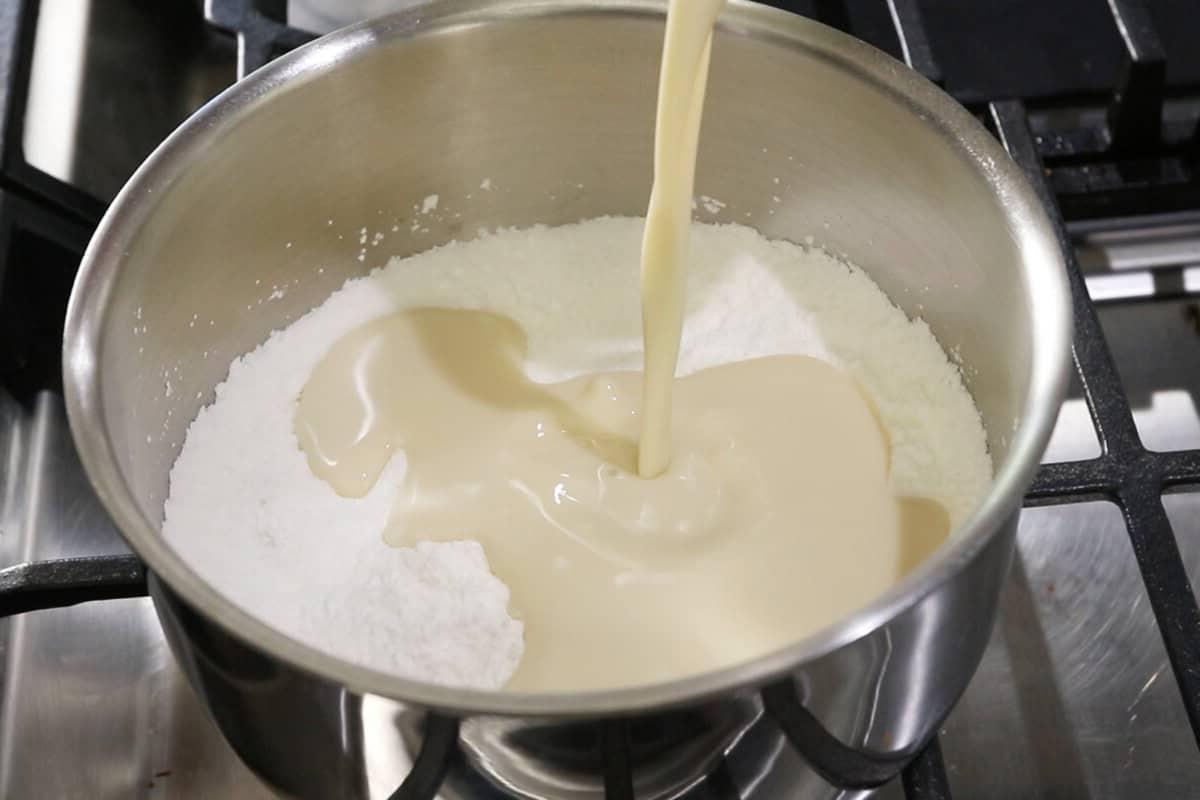 adding milk to cornstarch and sugar in a pot