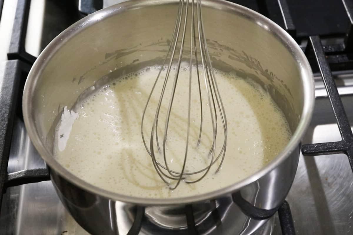 whisking milk in a pot