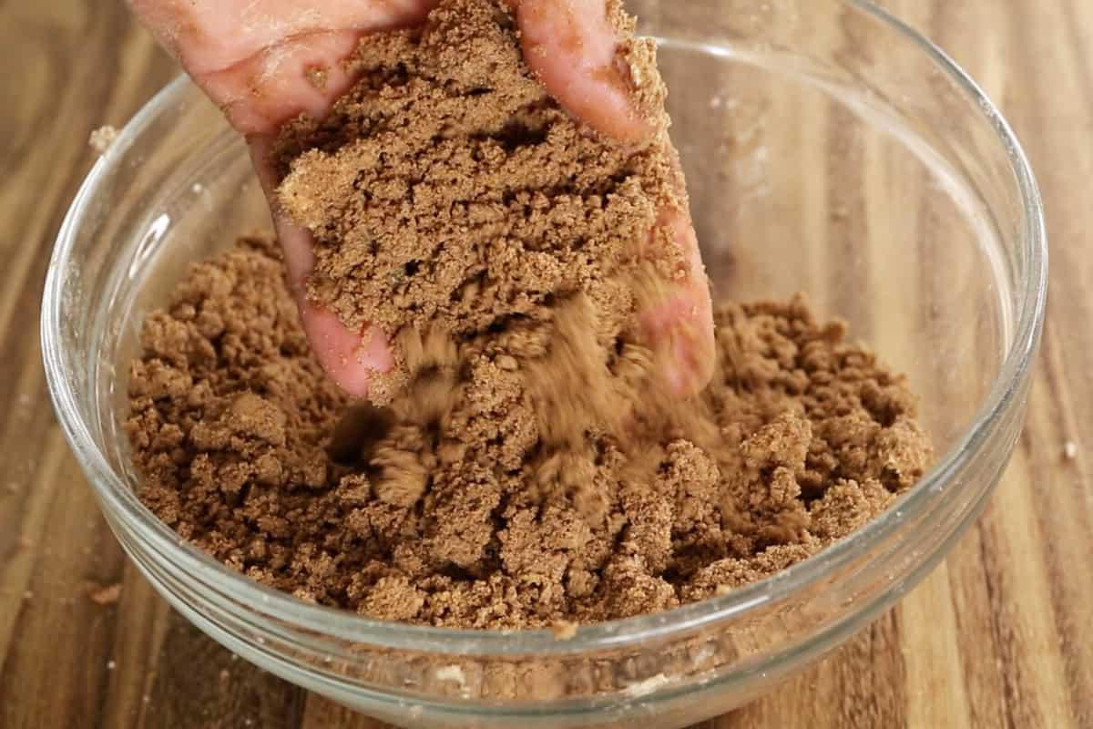 Ανάμιξη γέμισης streusel για βίγκαν κέικ καφέ σε γυάλινο μπολ