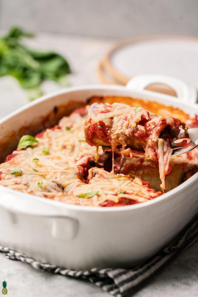 Eggplant rollatini in baking dish with piece being pulled out