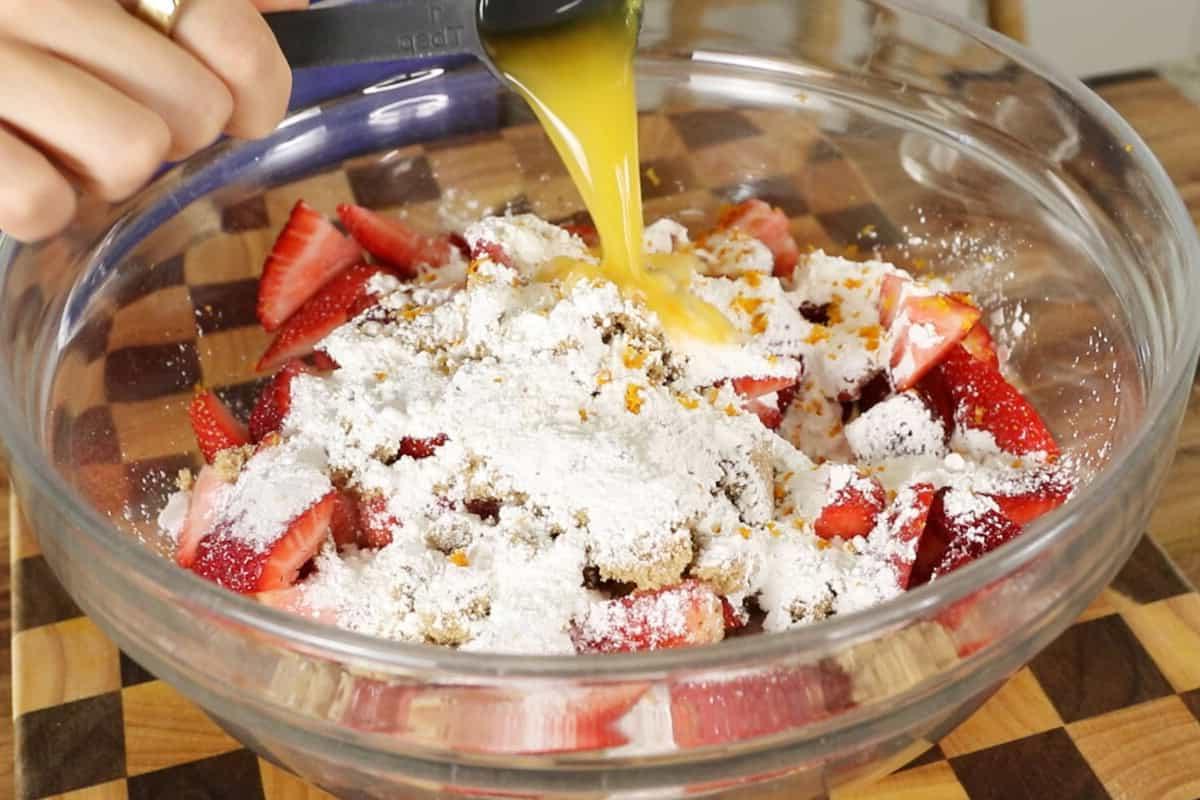 Βέγκαν Κραμπλ Φράουλας και Ραβεντιού 9 pouring orange juice into filling for strawberry rhubarb crisp in large glass bowl