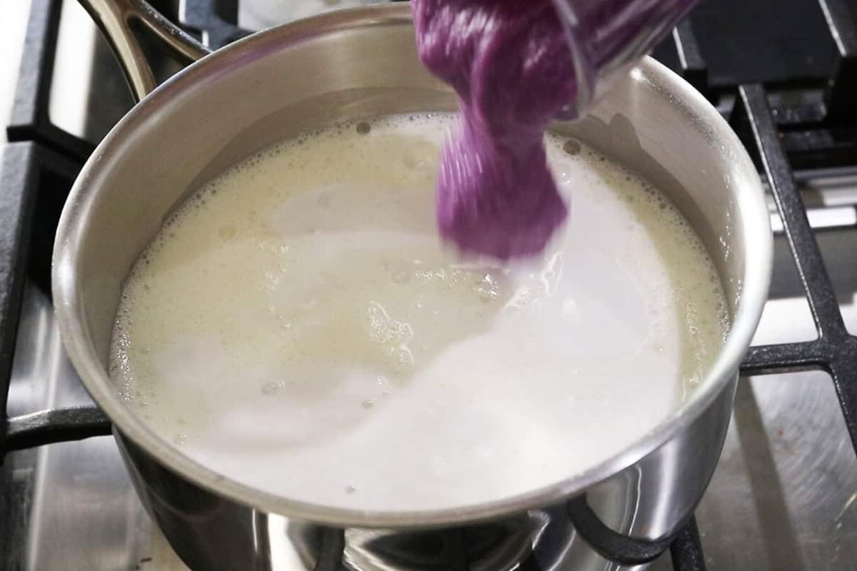 step by step - scooping ube halaya into pot of milk
