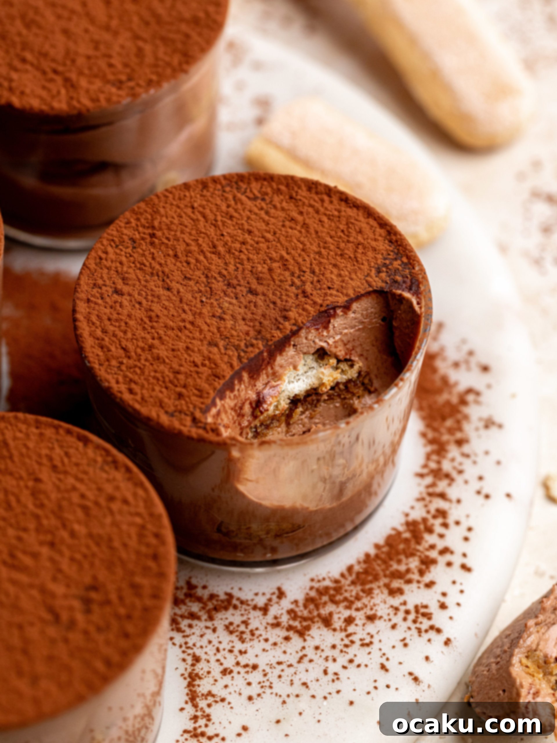 A stack of chocolate tiramisu cups in clear glass containers.
