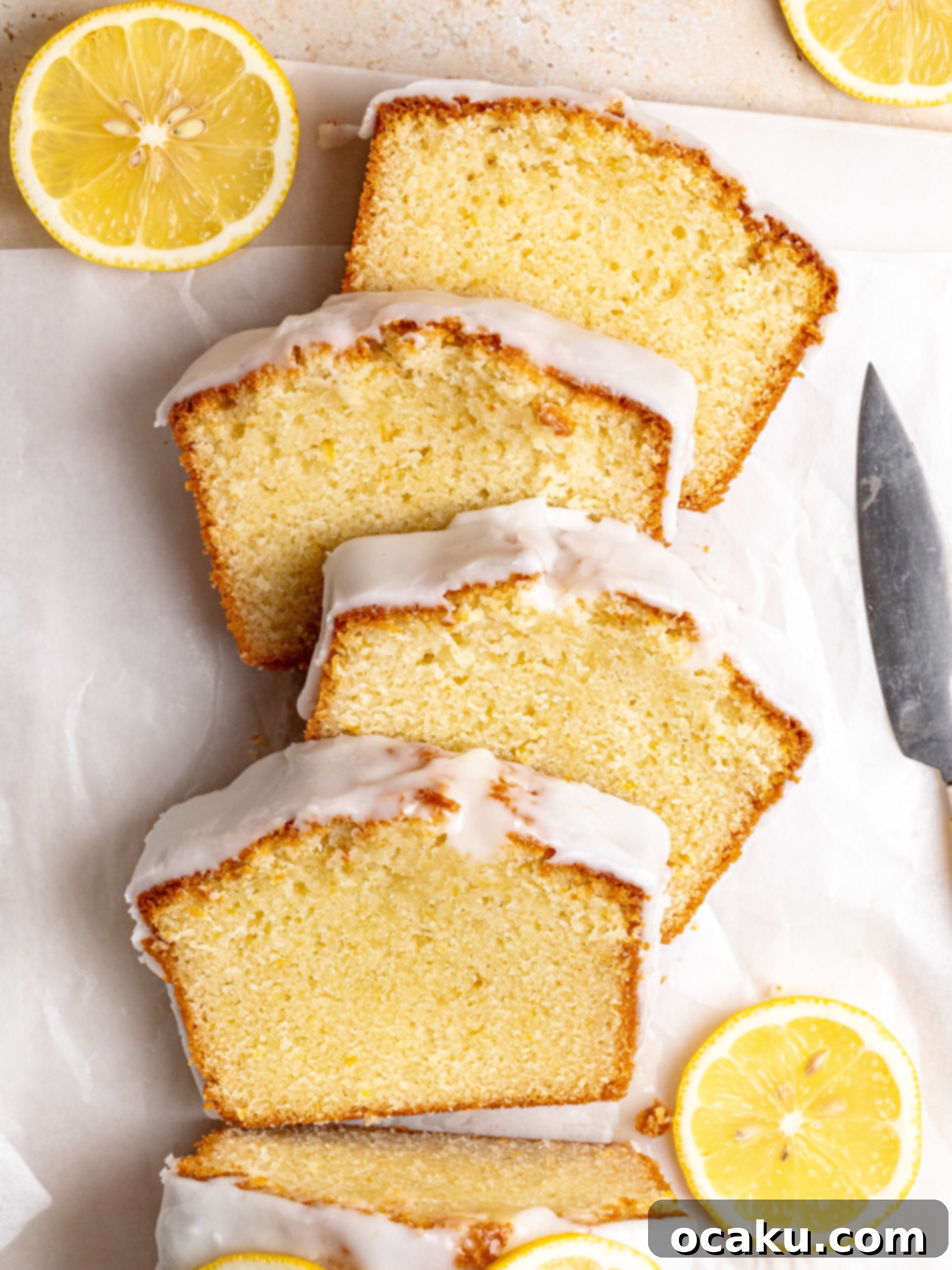 A close-up of a slice of lemon loaf cake on a fork, showing its moist texture and glaze.