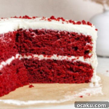 The Ultimate Red Velvet Cake 9 A slice of Red Velvet Cake with a red background