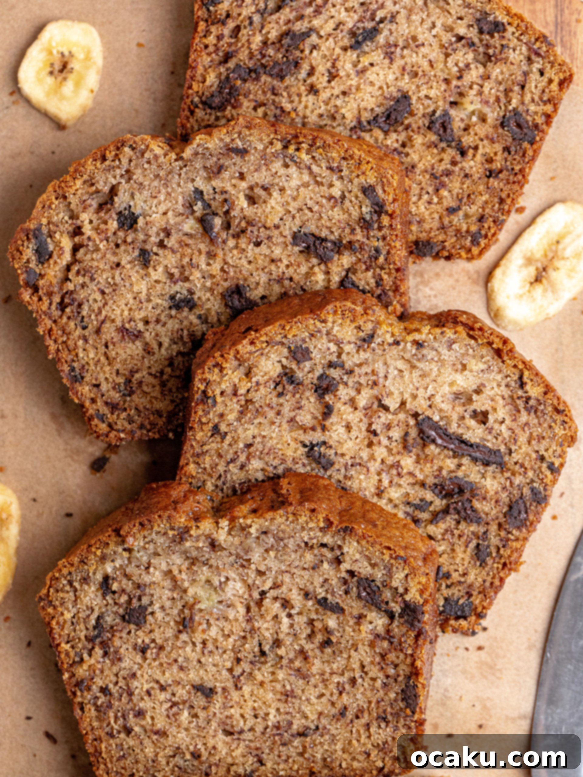 Effortless One-Bowl Banana Bread 5 A slice of dark chocolate banana bread on a white plate with a fork.