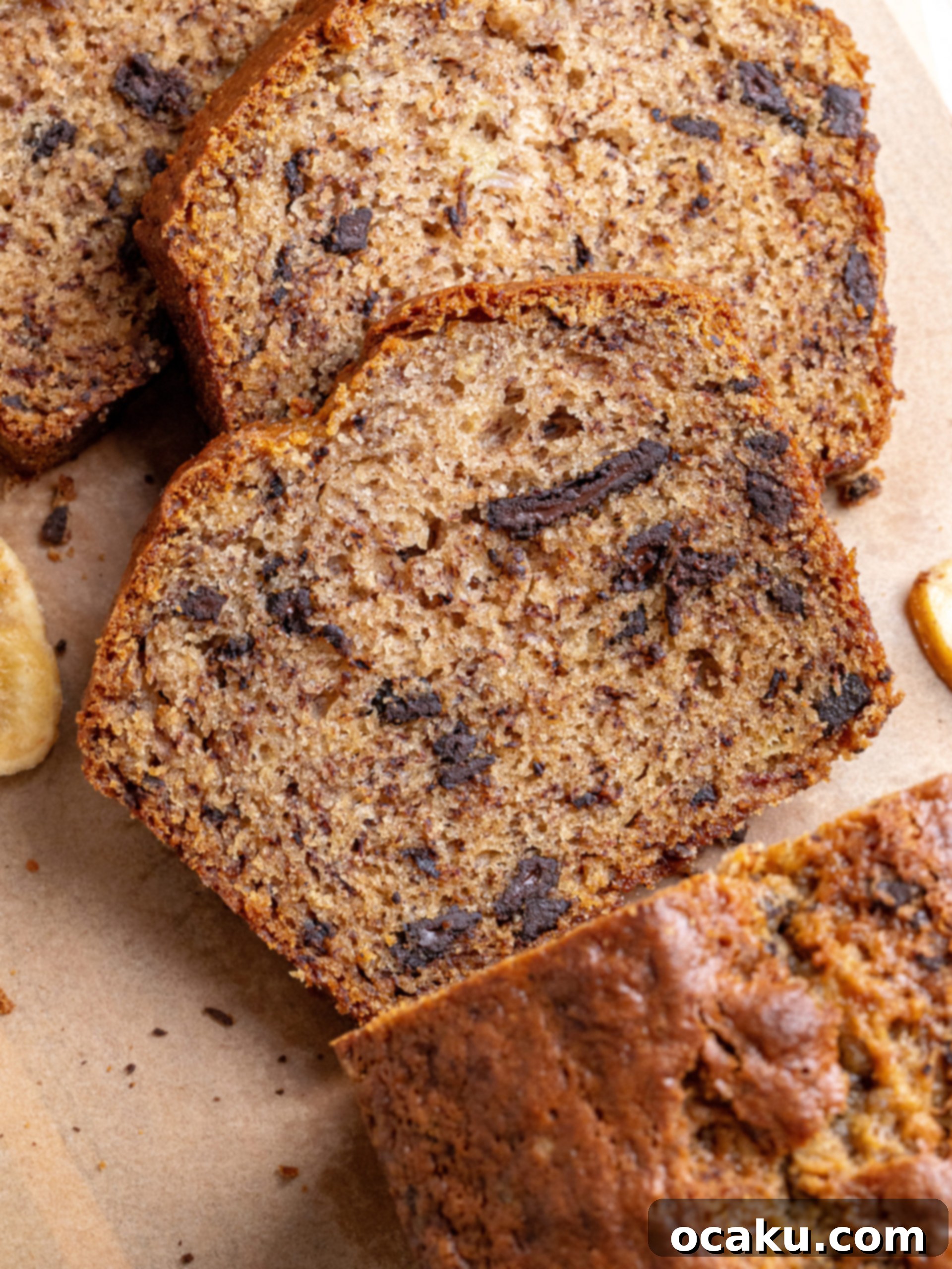 Effortless One-Bowl Banana Bread 6 Six slices of dark chocolate banana bread arranged on a wooden board.