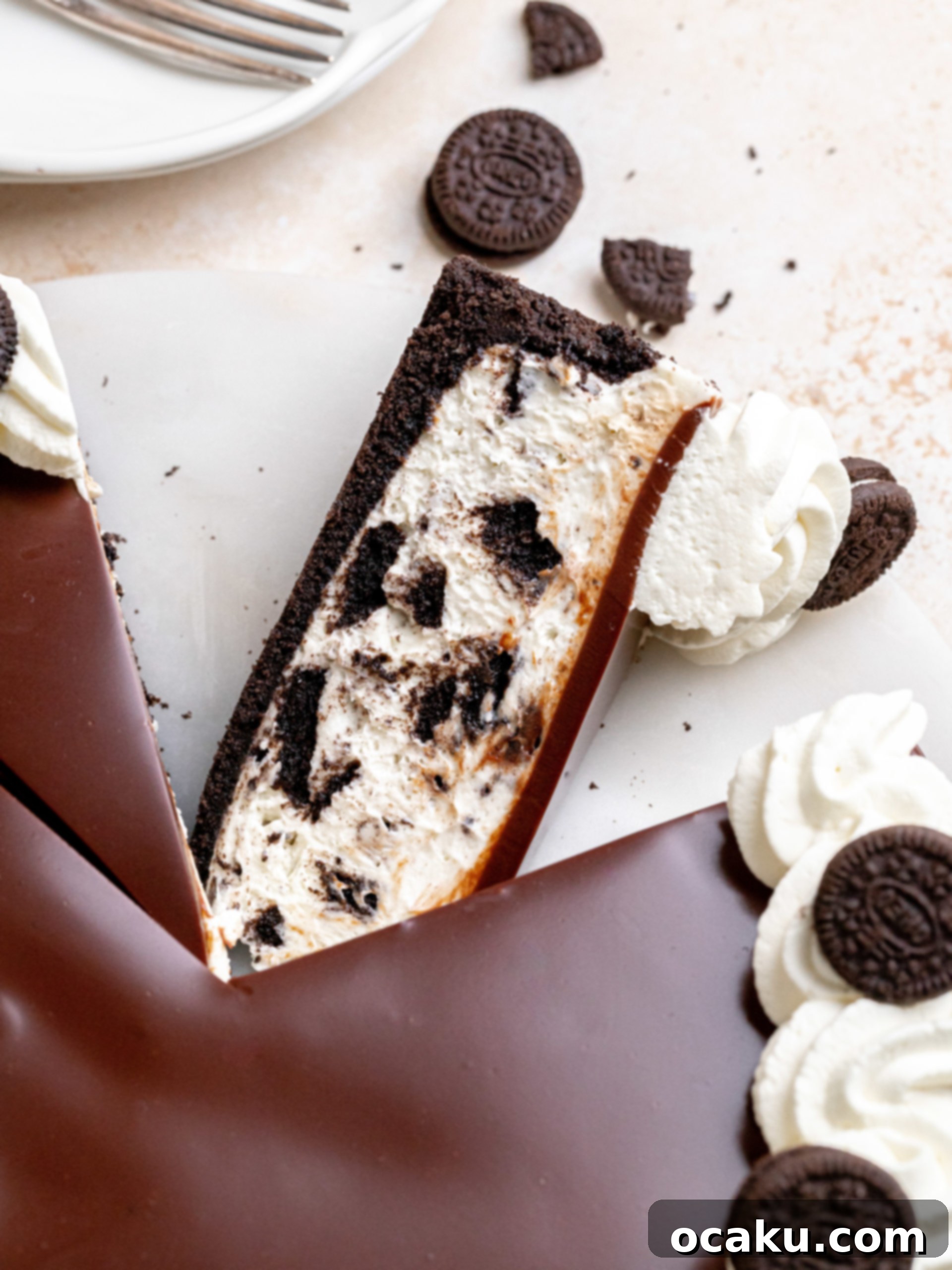 Easy No-Bake Oreo Cheesecake 2 A stunning slice of No-Bake Oreo Cheesecake with a rich chocolate ganache, whipped cream, and mini Oreos on top, showcasing the creamy filling and crunchy crust.