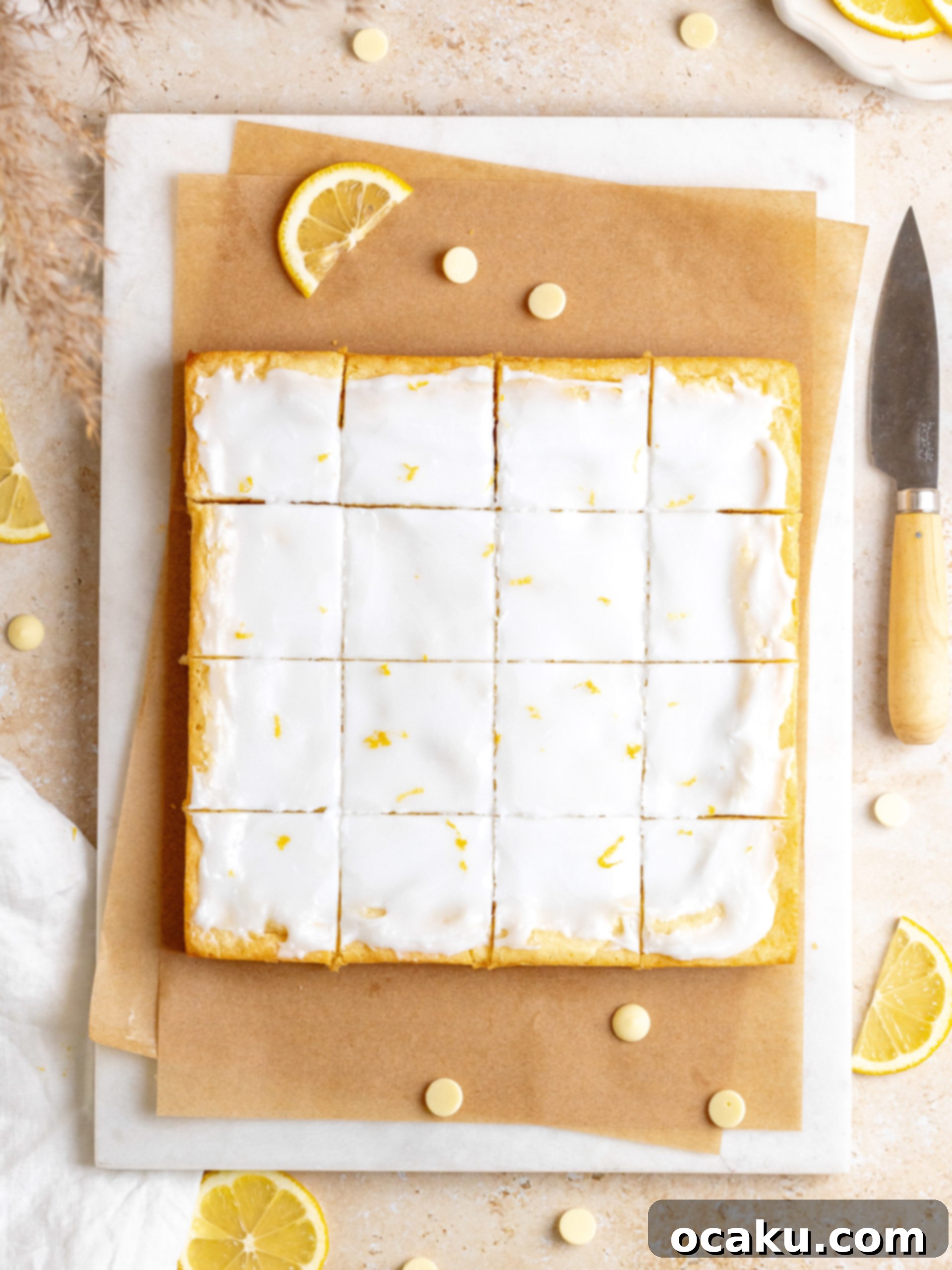 Aperol Spritz Cheesecake Lemon brownie batter being spread into a square baking pan lined with parchment paper.