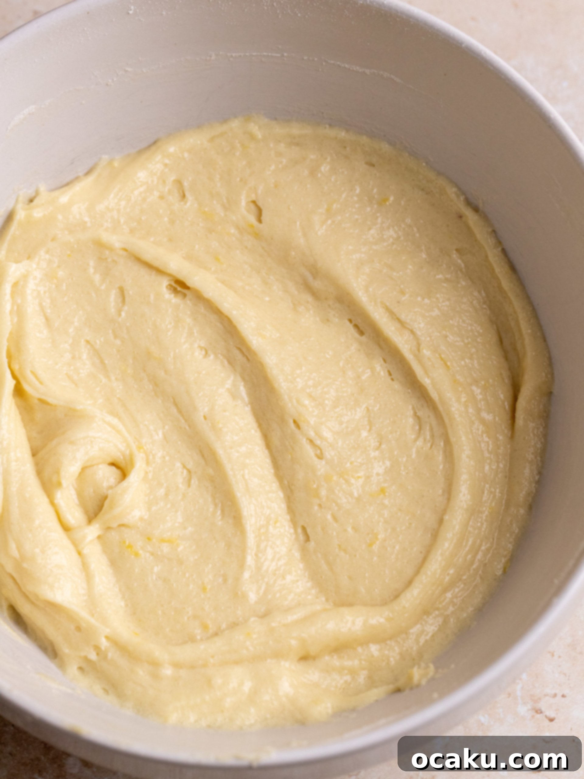 Zesty Lemon Fudge Squares 3 Lemon brownie batter being smoothed in a baking pan.