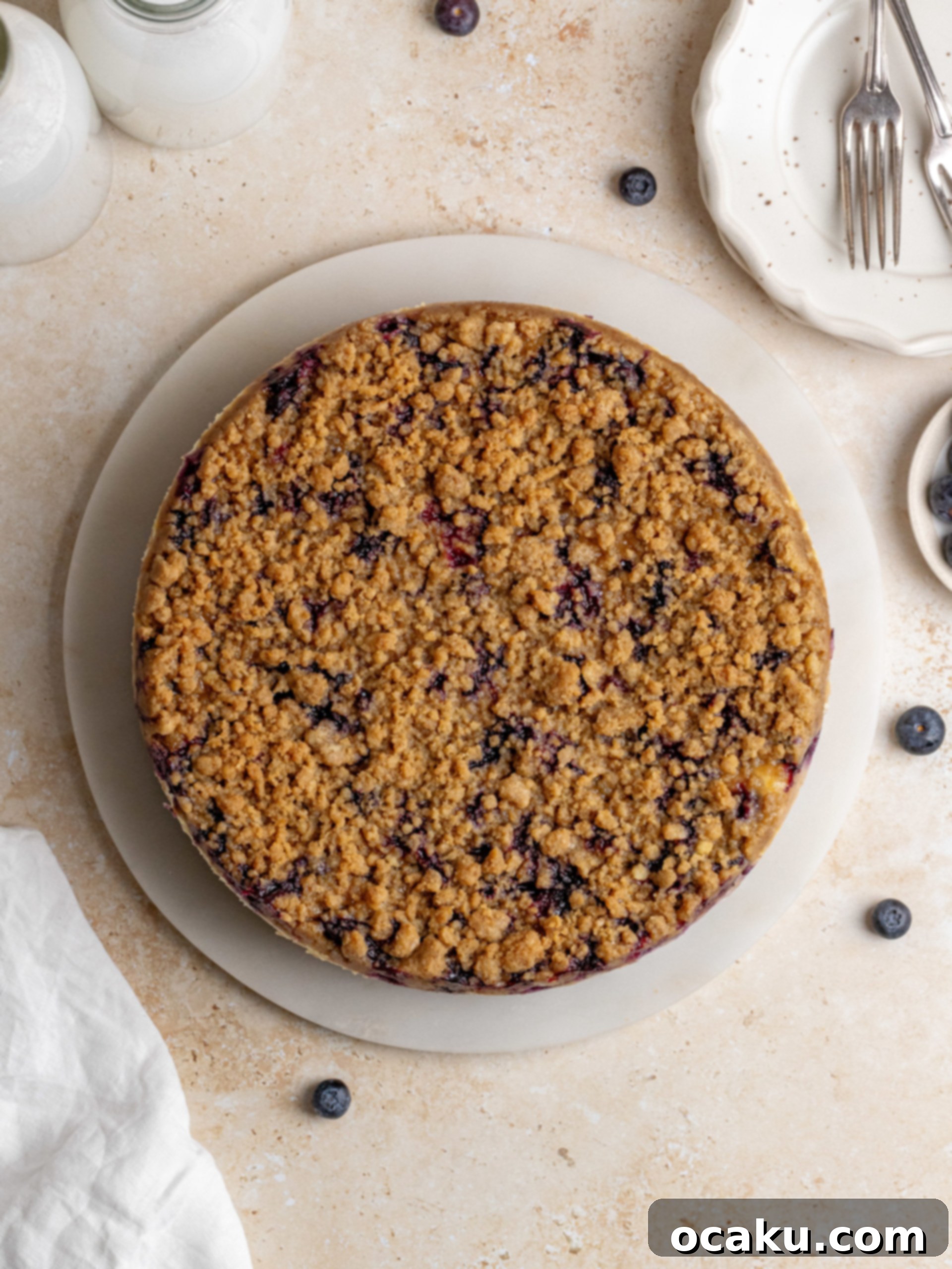 The blueberry crumble cheesecake in a springform pan, placed in a water bath, ready for baking.