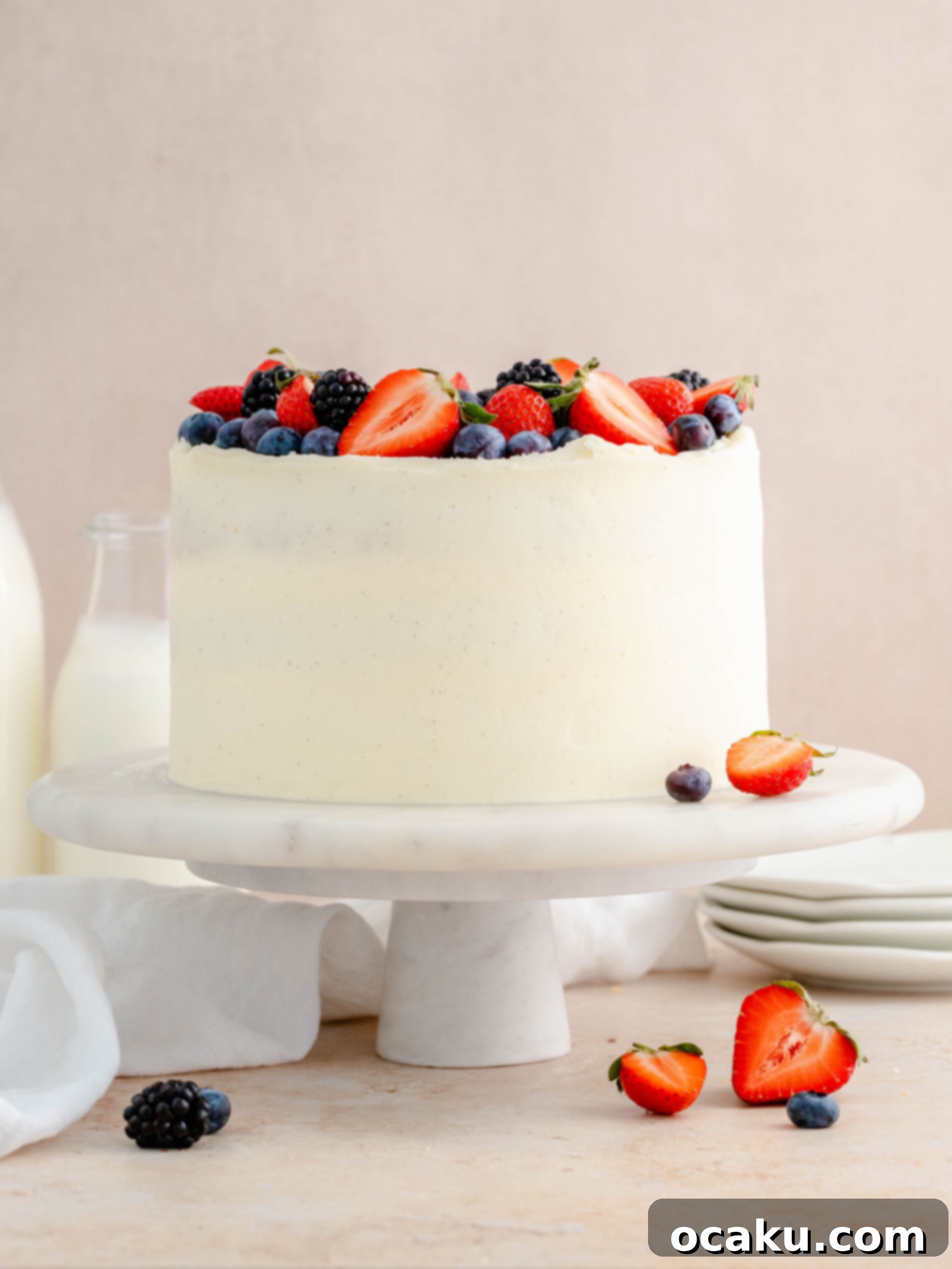 Close-up of strawberry and blueberry layer cake slice, showing almond cake and compote