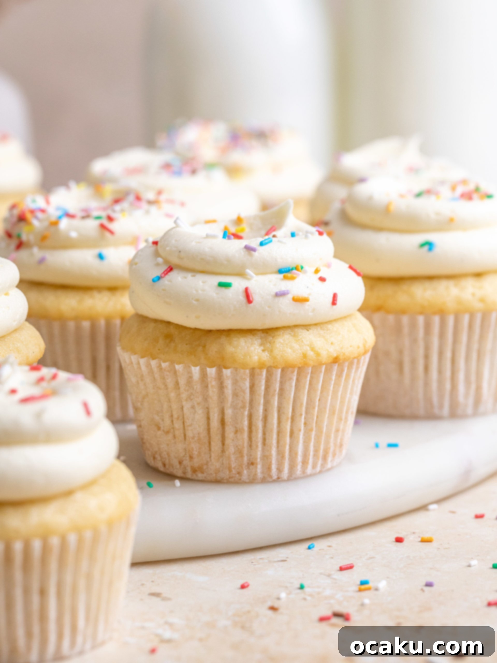 A close-up shot of a vanilla birthday cupcake, showcasing its moist crumb and fluffy texture.