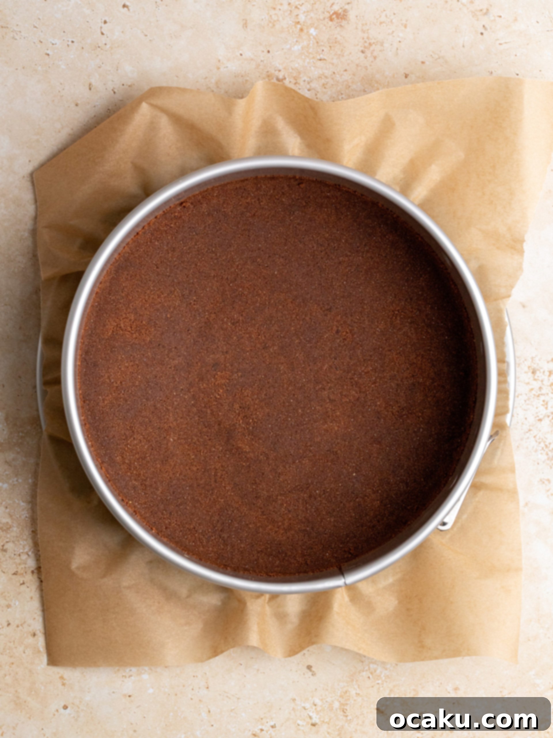 Cookie crust pressed firmly into a springform pan, showing a smooth and even base.