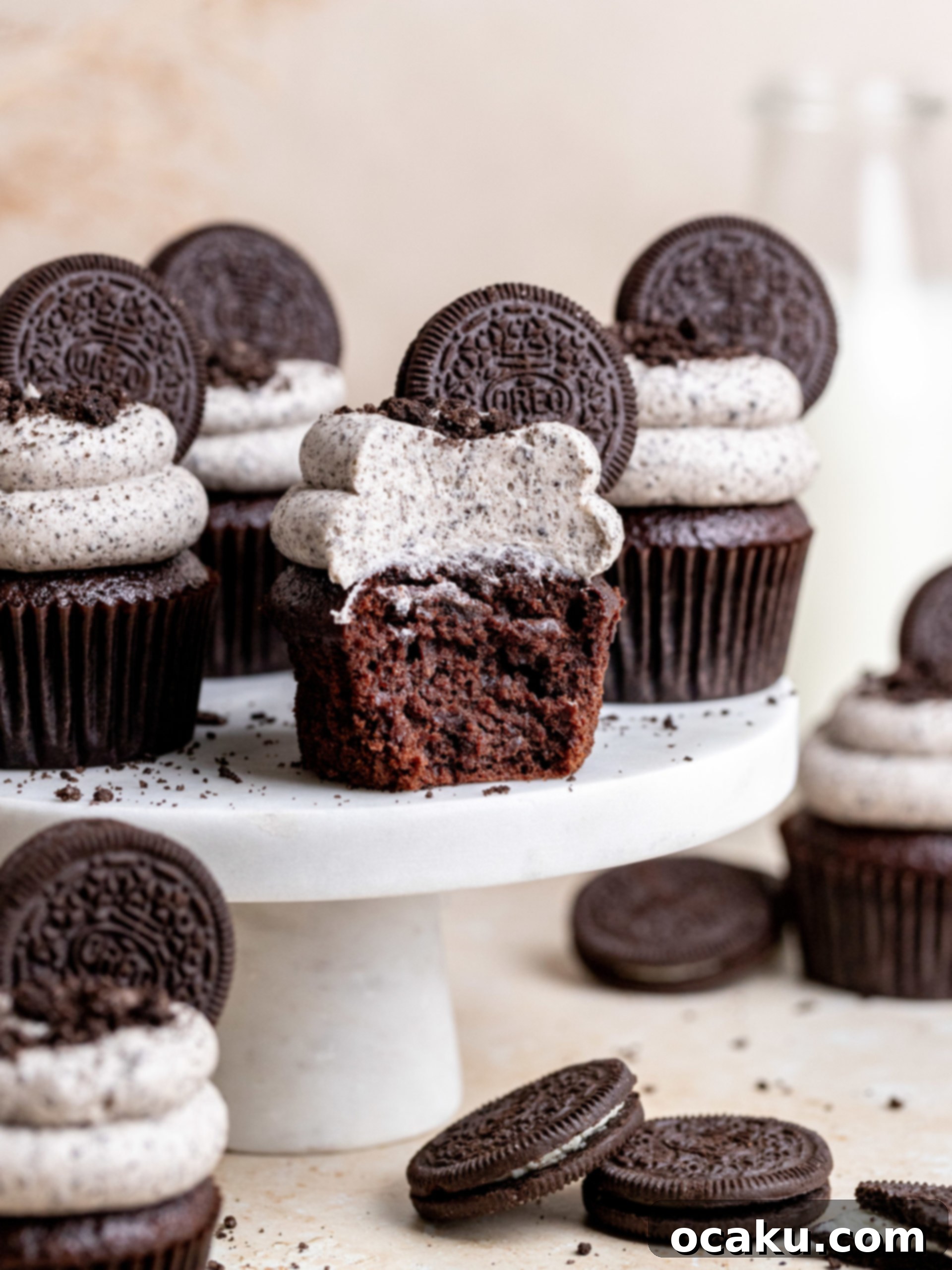 A trio of perfectly frosted Oreo cupcakes with whole Oreos and crumbs, presented beautifully as a finished dessert.