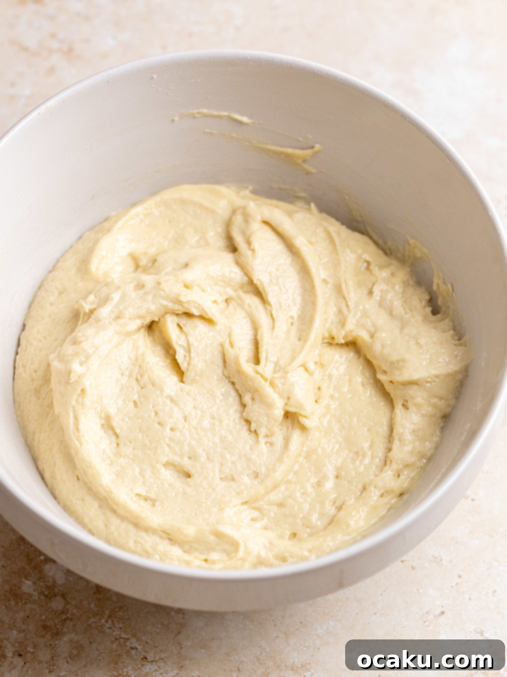 Strawberry Streusel Cake 4 Eggs being added one by one to the creamed butter and sugar mixture.