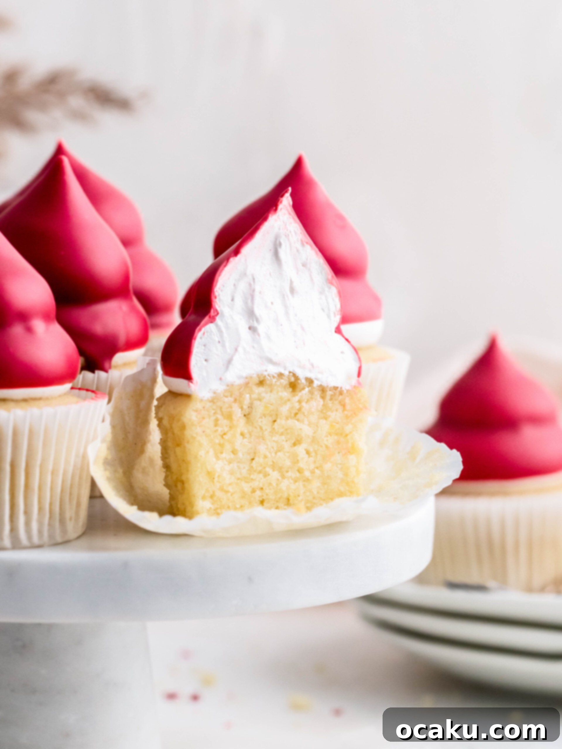 Raspberry cream puff cupcakes cut in half on a tray, showcasing their fluffy interior.