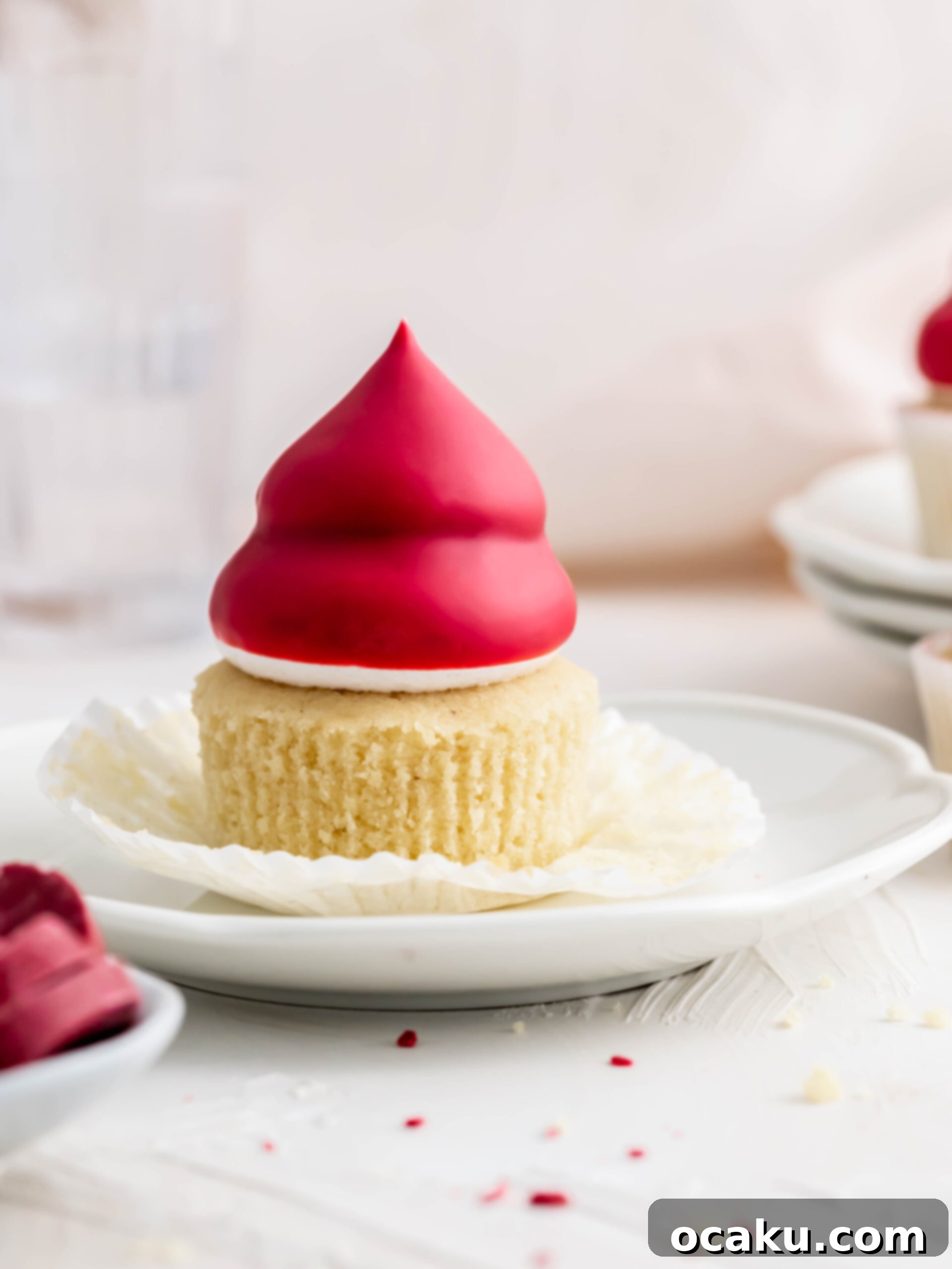 A single Raspberry Cream Puff Cupcake on a white plate, ready to be enjoyed.