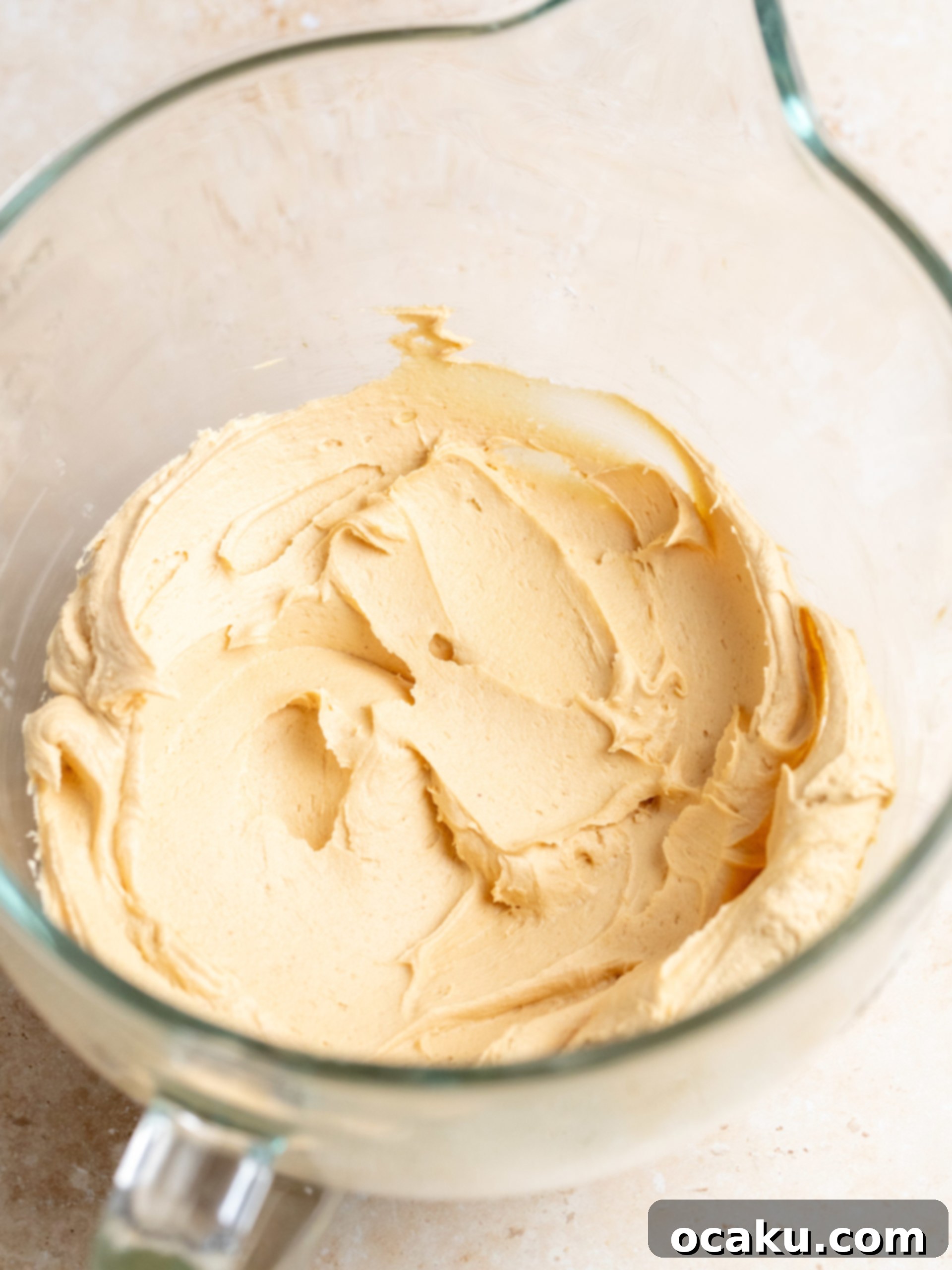 Powdered sugar being added to the creamy peanut butter mixture for frosting.