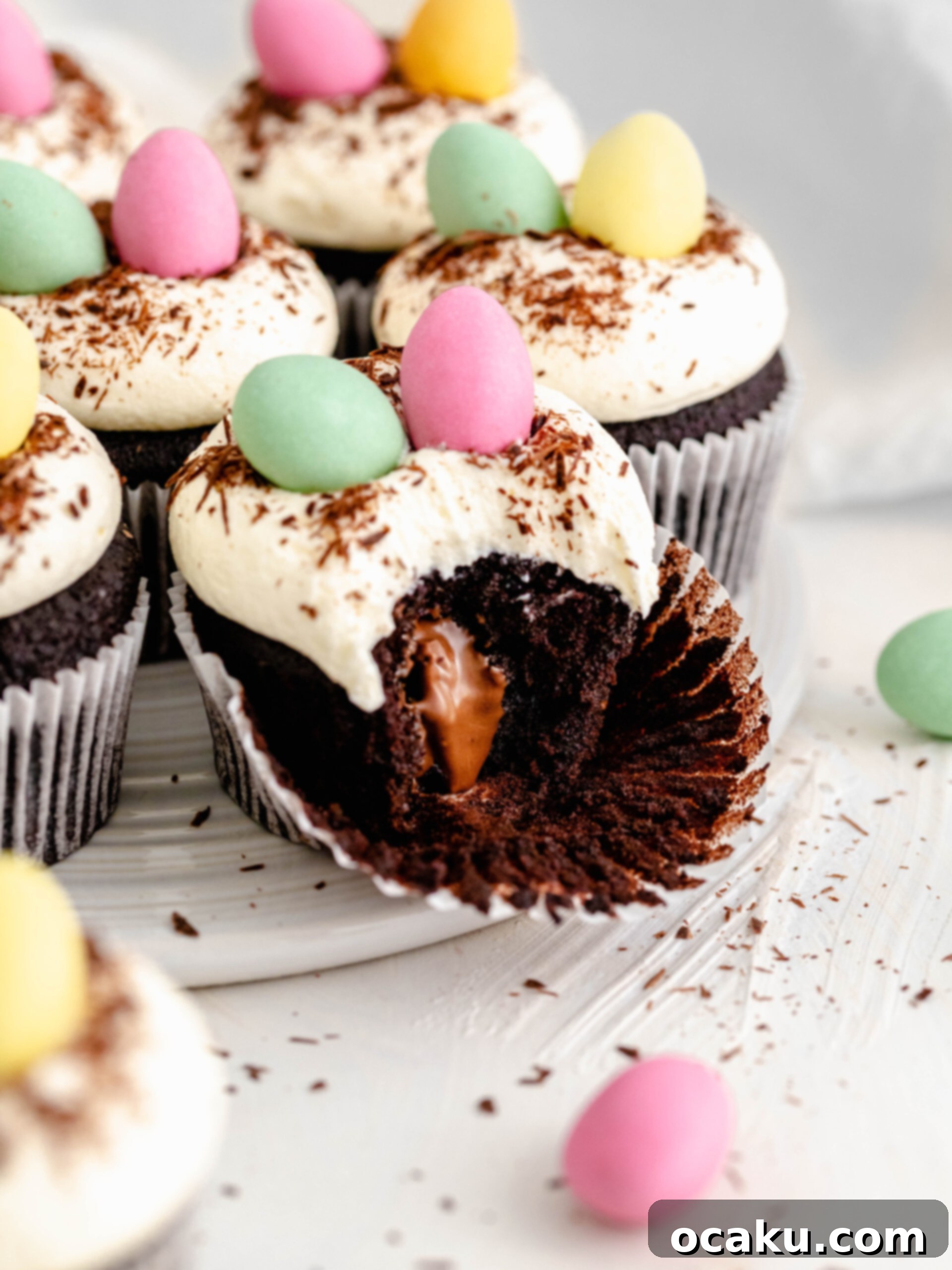 Easter Mini Egg Cupcakes 3 A mini egg chocolate cupcake with a bite taken, revealing the delightful surprise of a mini Easter egg hidden within.
