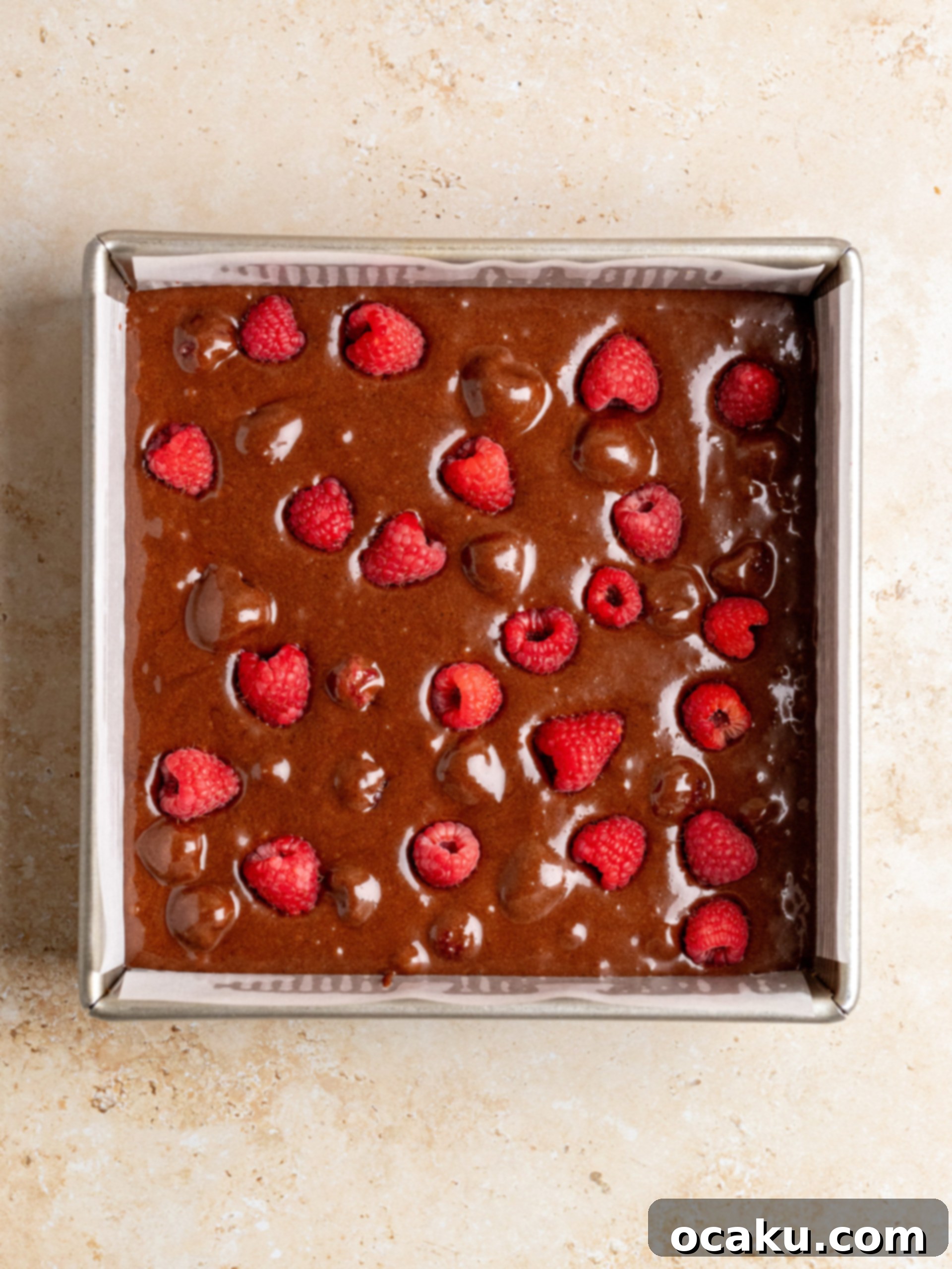Sugar and eggs being whisked into the chocolate mixture in a large bowl.