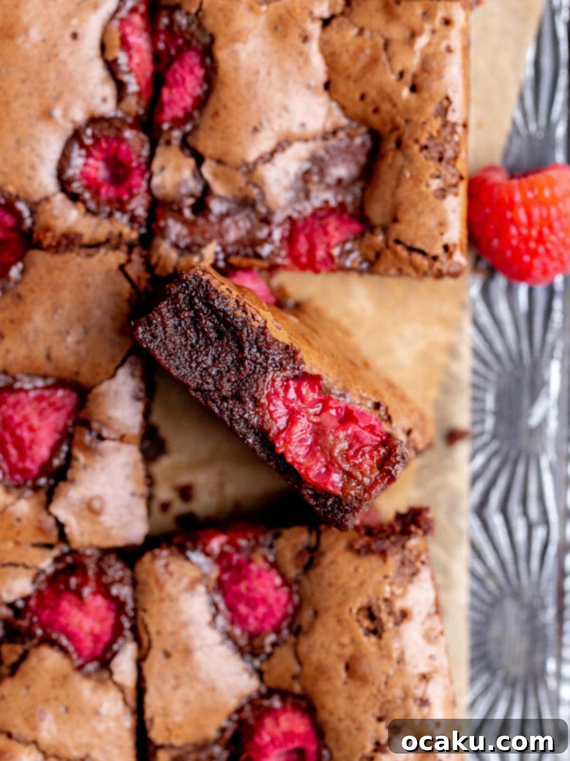 A large batch of freshly cut raspberry brownies arranged on a cooling rack.