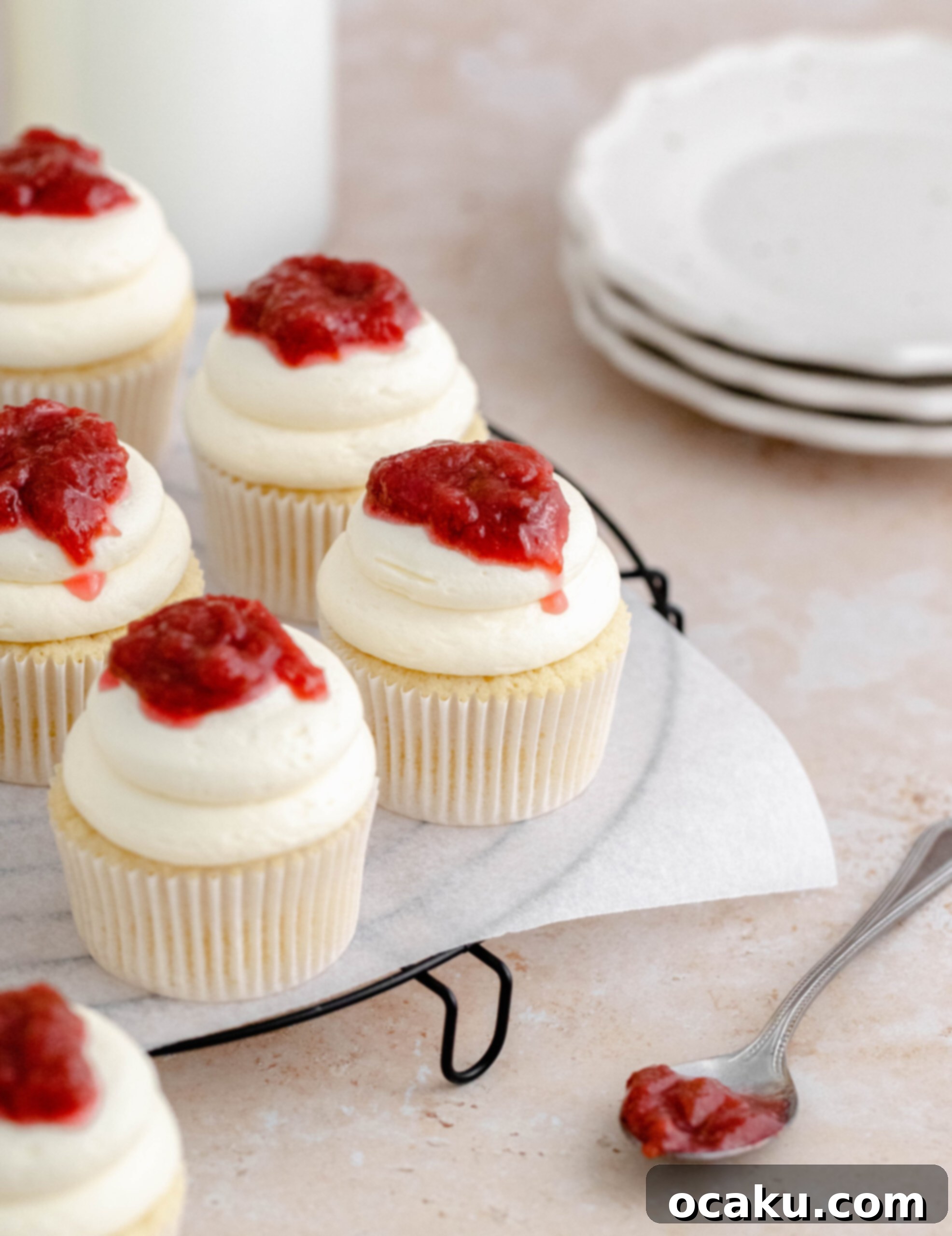 A batch of freshly baked rhubarb and almond cupcakes cooling on a wire rack.