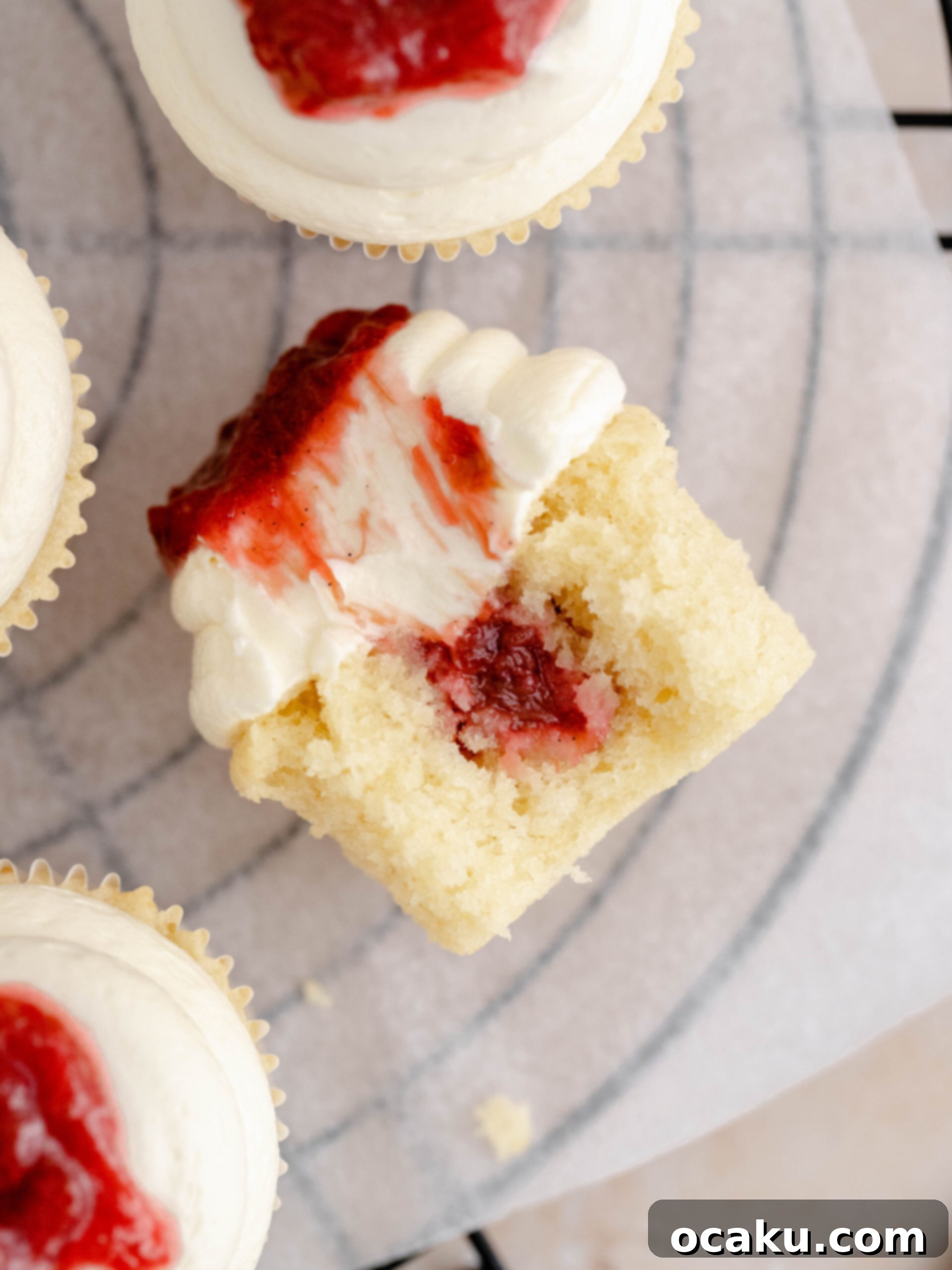 A single rhubarb and almond cupcake on a baking tray, showcasing its golden-brown top.