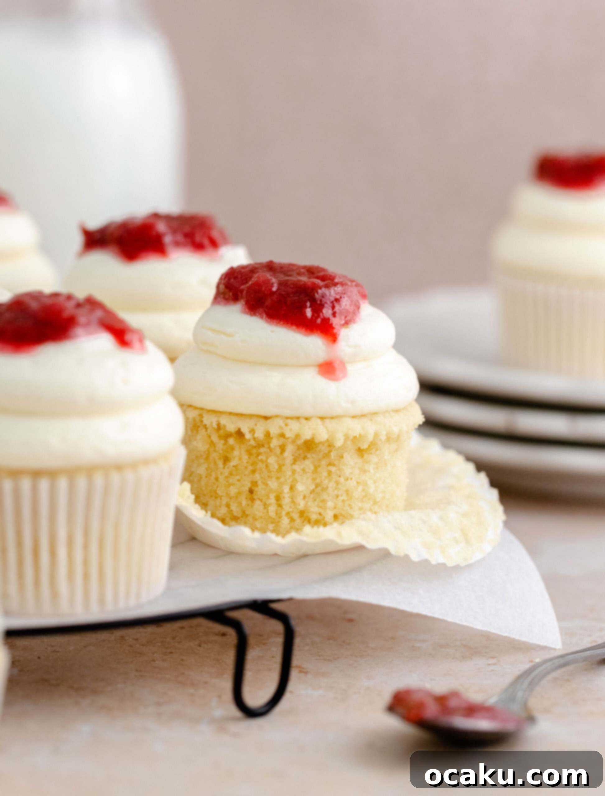 A freshly piped rhubarb and almond cupcake, topped with a dollop of compote.