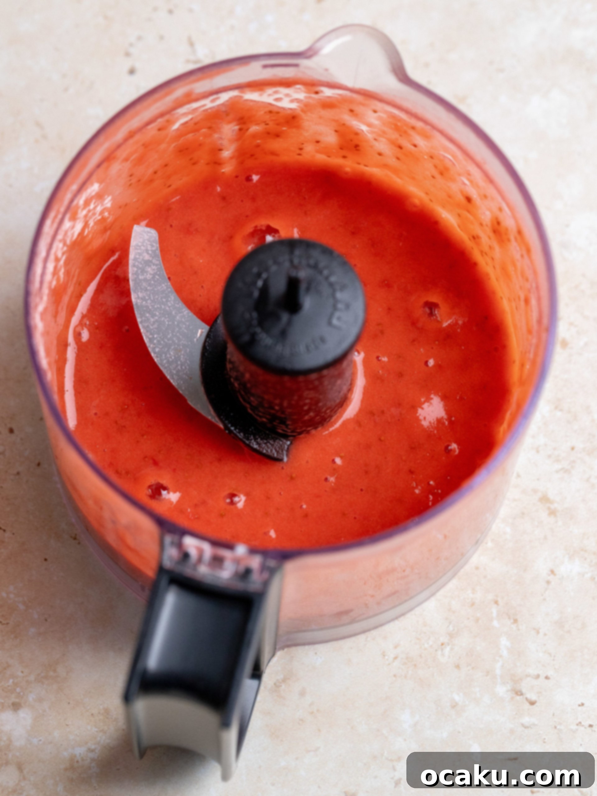 Adding sifted powdered sugar and strawberry powder to cream cheese frosting.