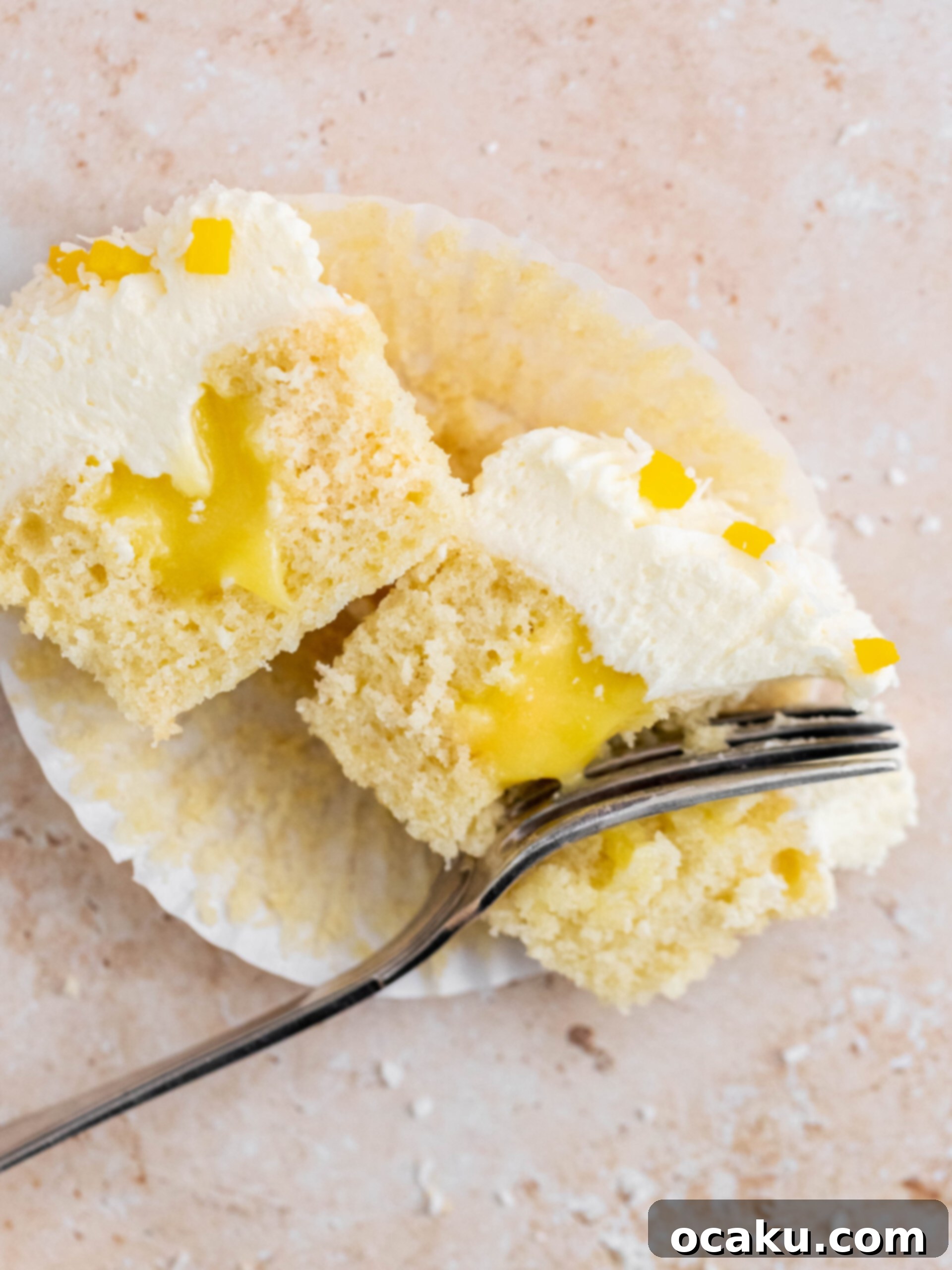 Mango Bliss Cupcakes 3 A mango and coconut cupcake, perfectly cut in half to showcase its moist coconut base and the generous, bright yellow mango curd filling.