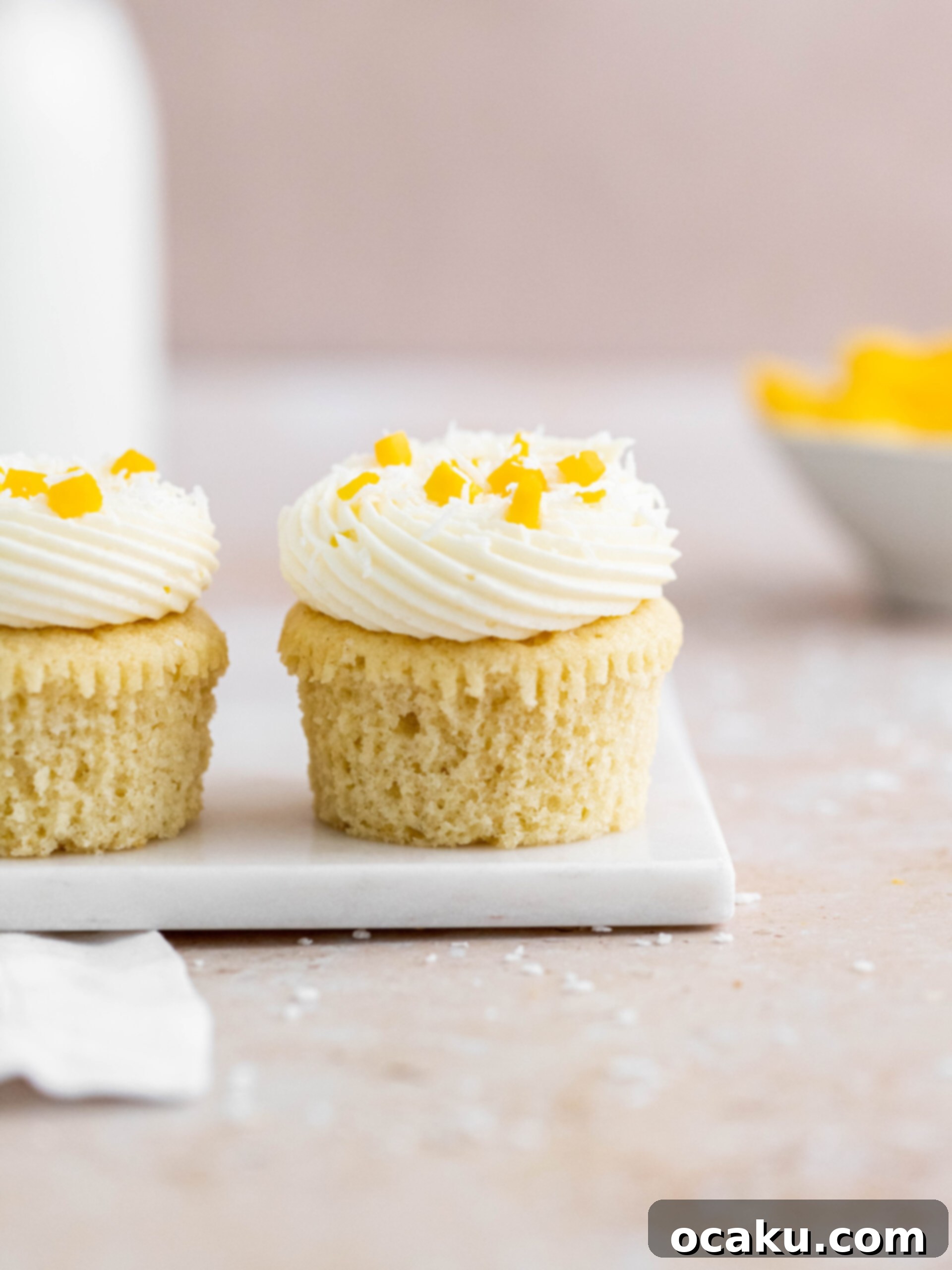 Mango Bliss Cupcakes 4 A tray filled with freshly baked coconut and mango cupcakes, cooling on a rack, awaiting their delicious frosting and filling.