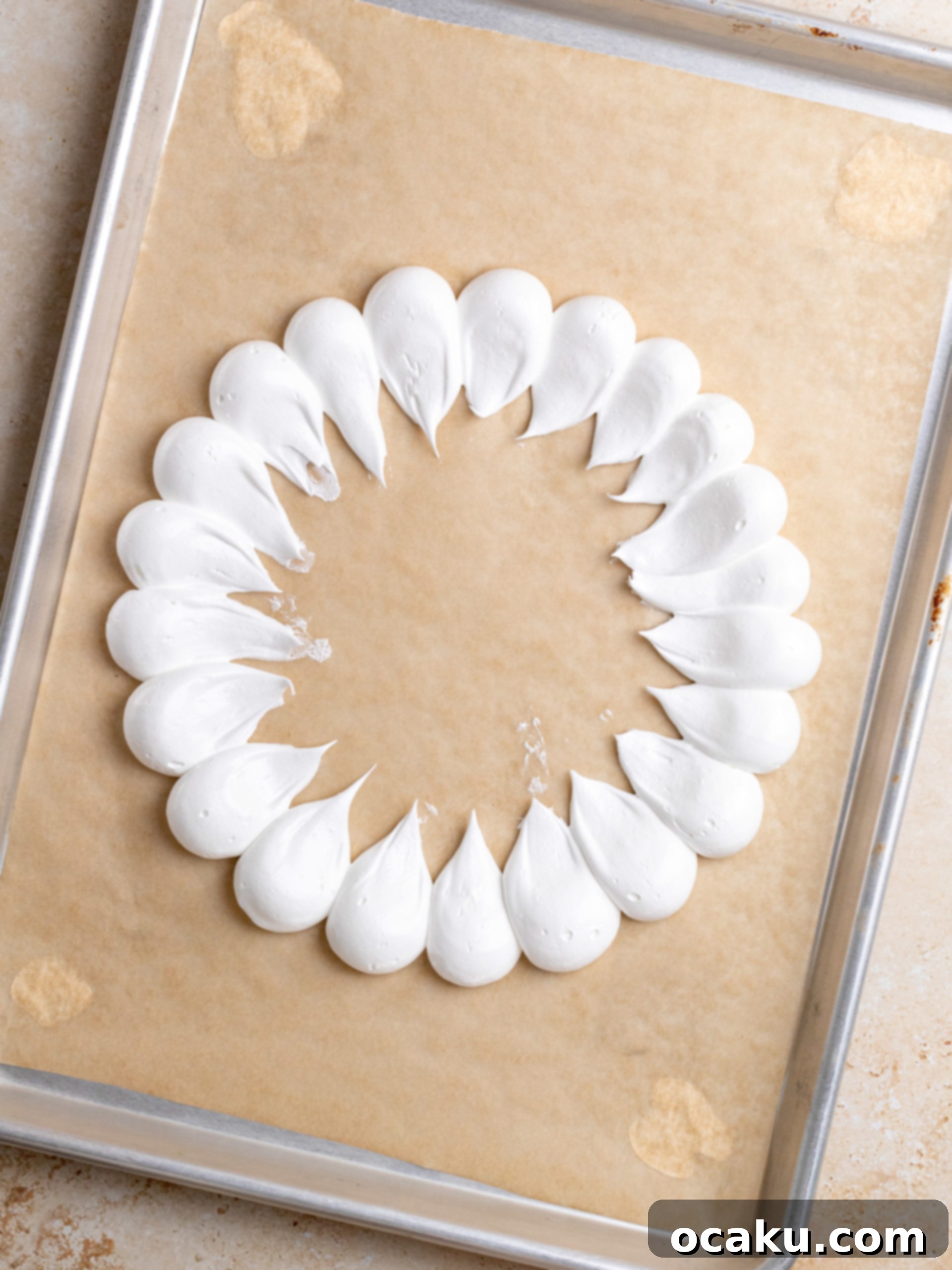 Piping round dollops of meringue onto parchment paper following a circular guide