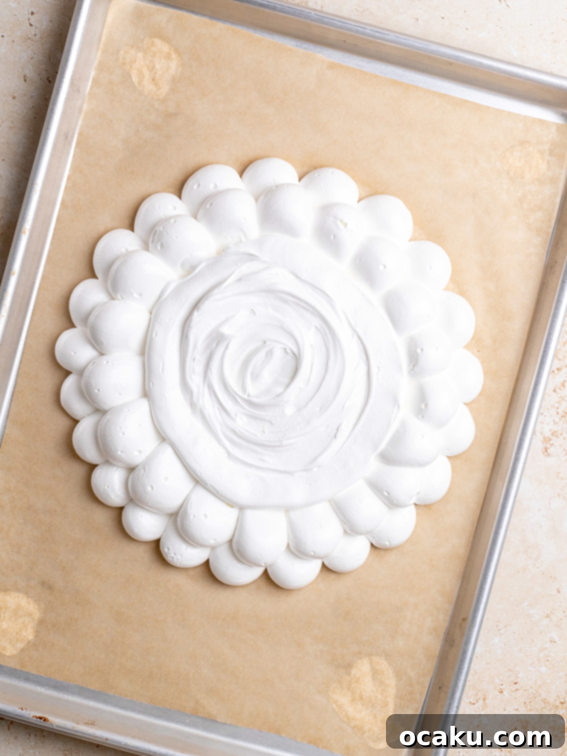Chantilly cream being piped onto the cooled pavlova shell, forming a fluffy topping