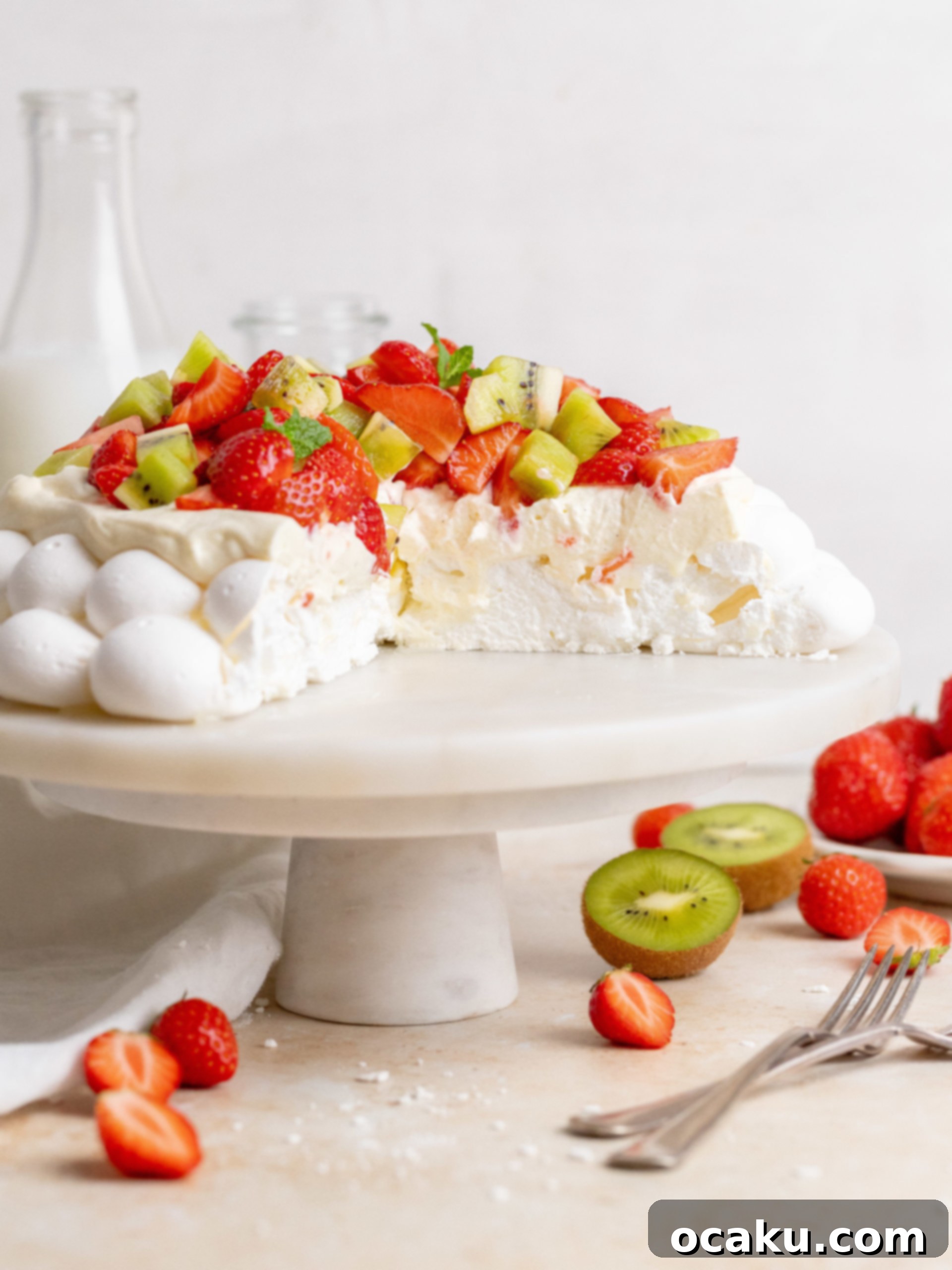 Close-up of a slice of Summer Pavlova, showing the layers of crisp meringue, Chantilly cream, and fresh fruit