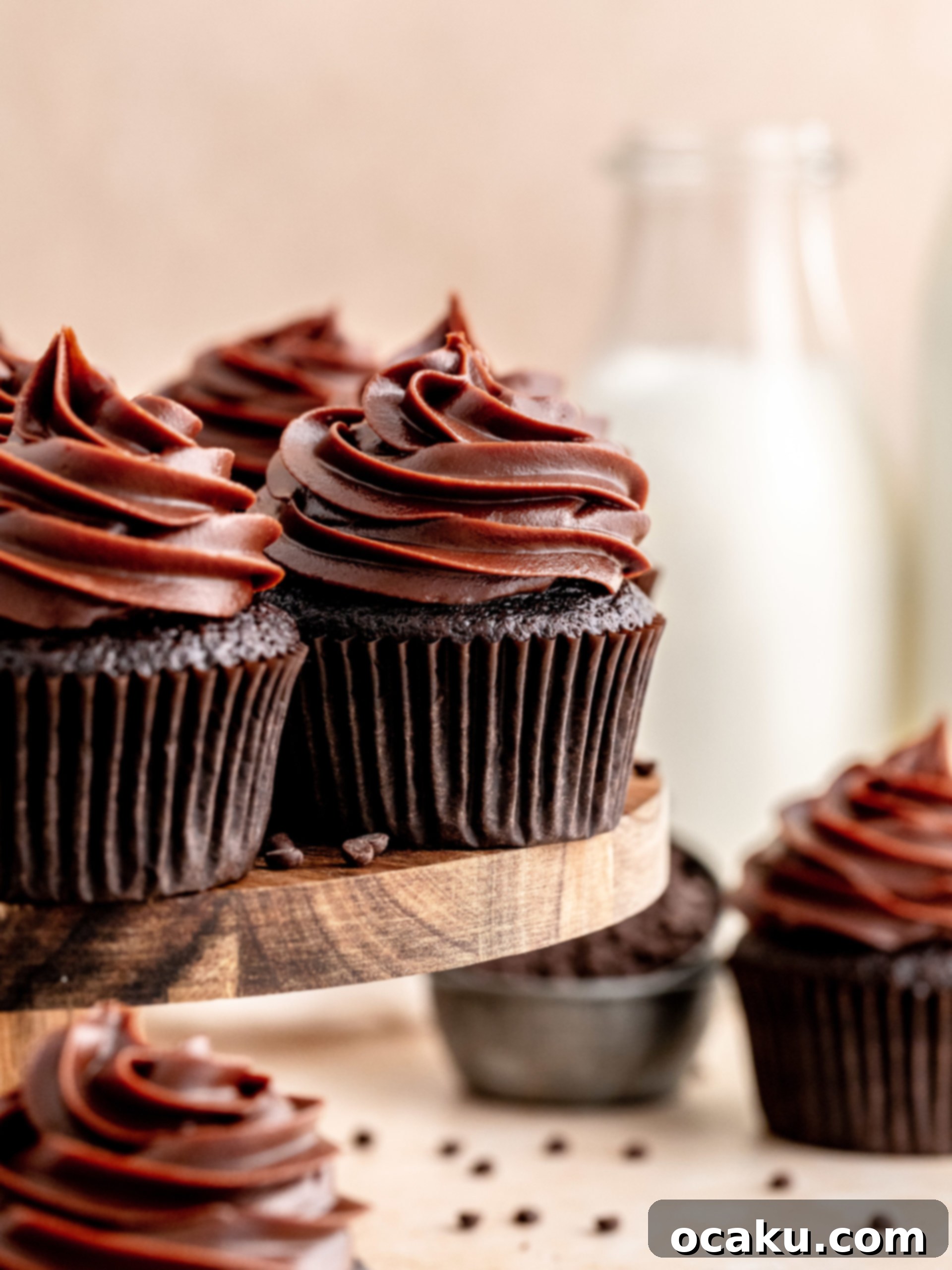 Piping chocolate fudge frosting onto a cupcake